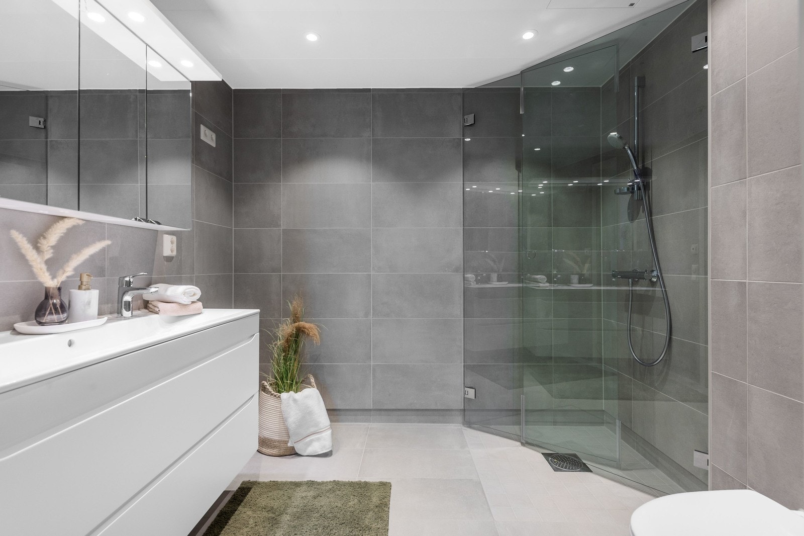 Hovedbad - flislagt, servant og vegghengt klosett samt dusjnisje Galleribilde