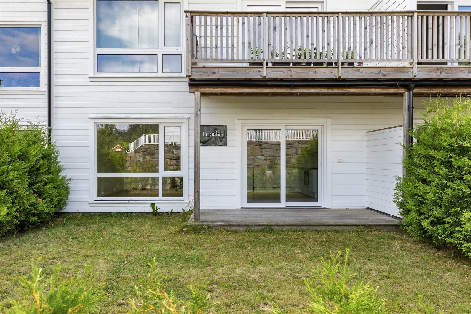 Fin og solrik uteplass med nyplantet hekk mot veien Galleribilde