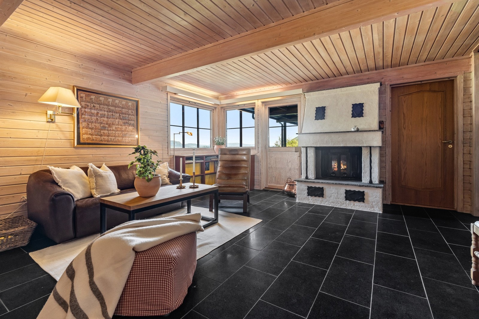 Hyggelig kjellerstue med peis og utgang til hage Galleribilde