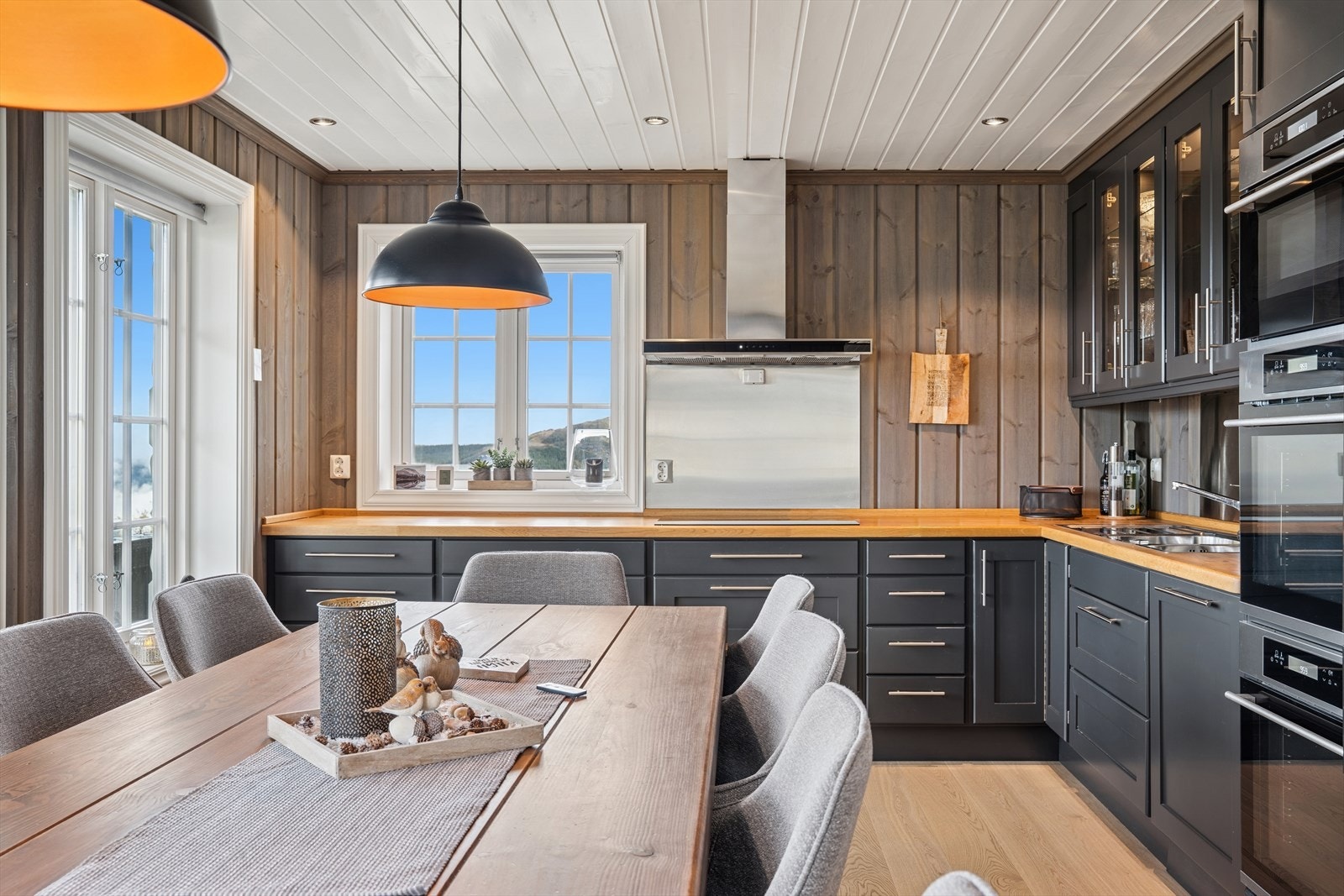 Belysningen og rommets utforming gir en god arbeidsflyt og en behagelig atmosfære, perfekt for både hverdagsbruk og sosiale sammenkomster. Galleribilde