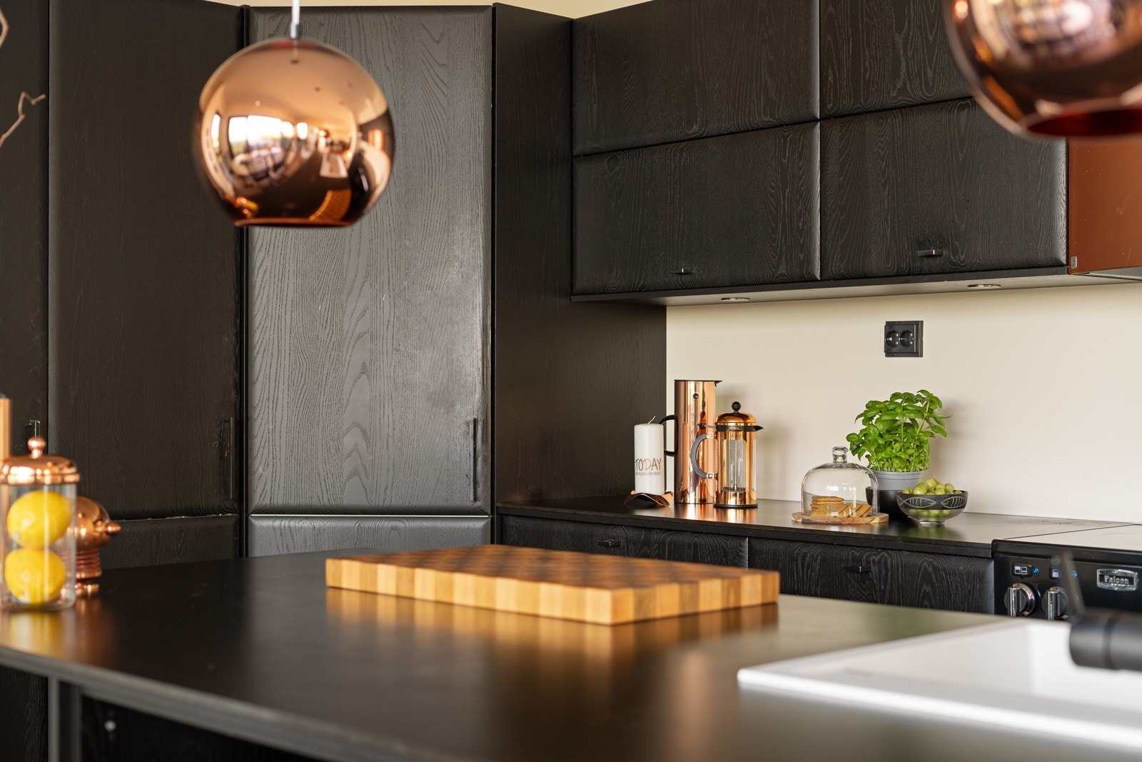 Kjøkkenet er stilrent og moderne, med glatte fronter, kjøkkenøy og en elegant sort utførelse som setter et sofistikert preg på rommet. Galleribilde