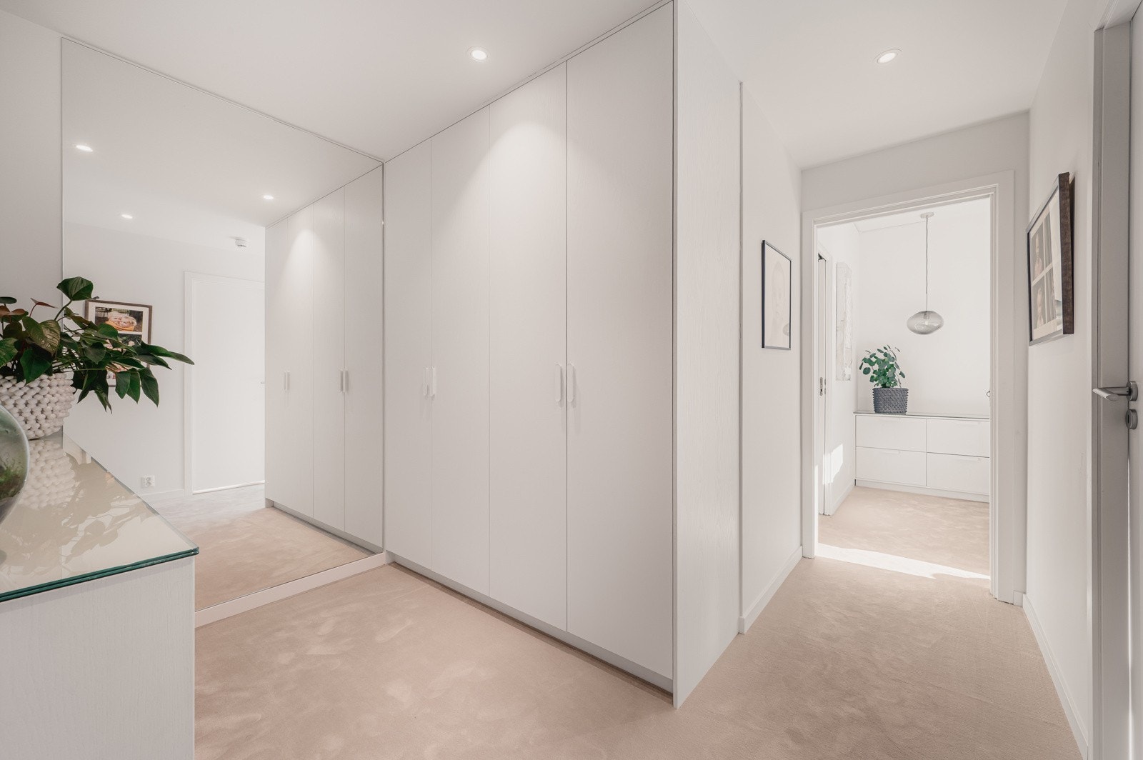 Videre er det tilkomst til leilighetens soveroms-fløy. Mellom rommene er det innredet godt med snekkerbygget garderobe. Galleribilde