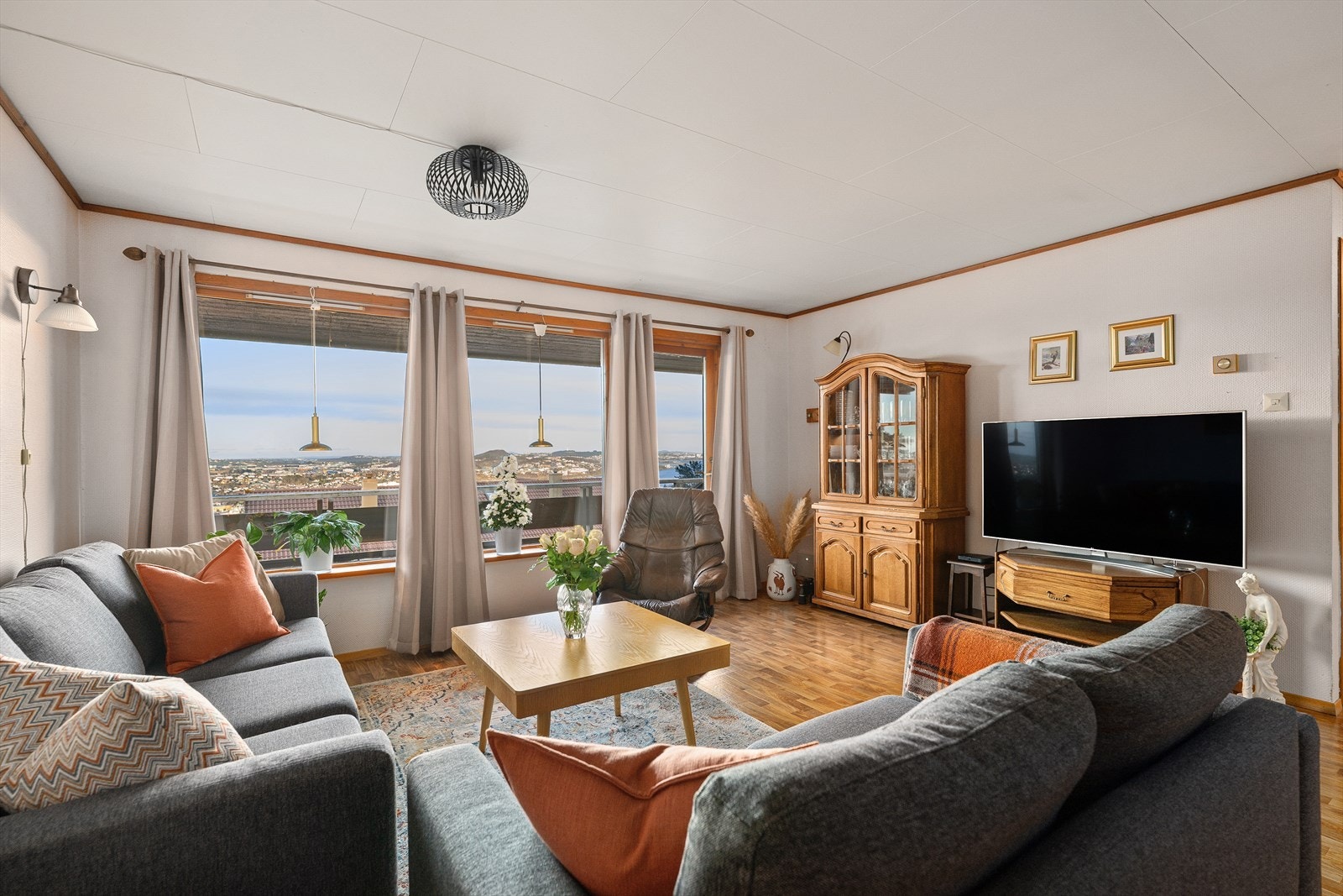 Atmosfæren i stuen er lun og god, med både vedovn og varmepumpe. Galleribilde