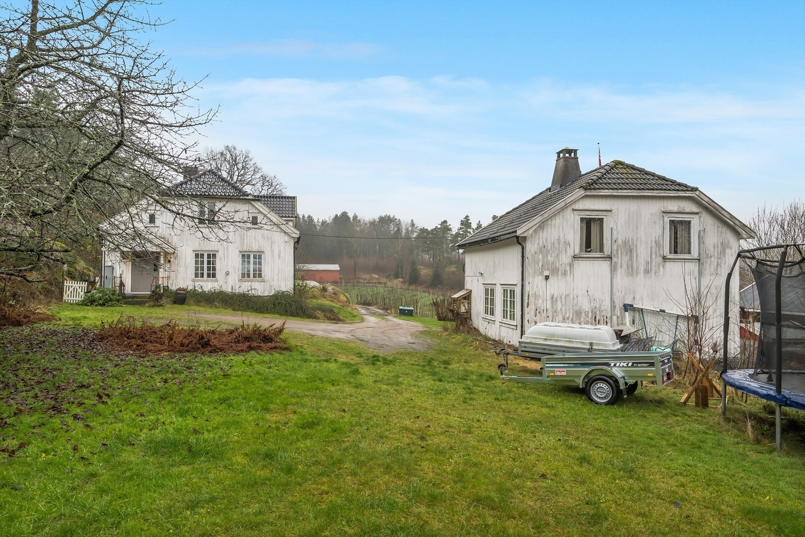 Romslig tun med plass til parkering, og potensiale for sikkelig landlig sjarm. Galleribilde
