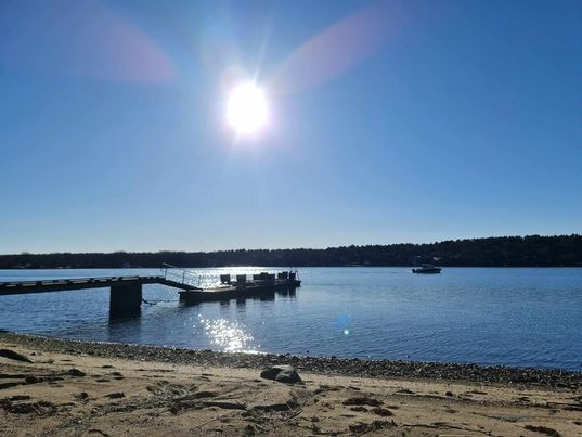 Bilde av bryggen på vestsiden av eiendommen med kveldssol. Brygge tilhører ikke eiendommen men er eid av og disponeres av hytteeiere i området. Galleribilde