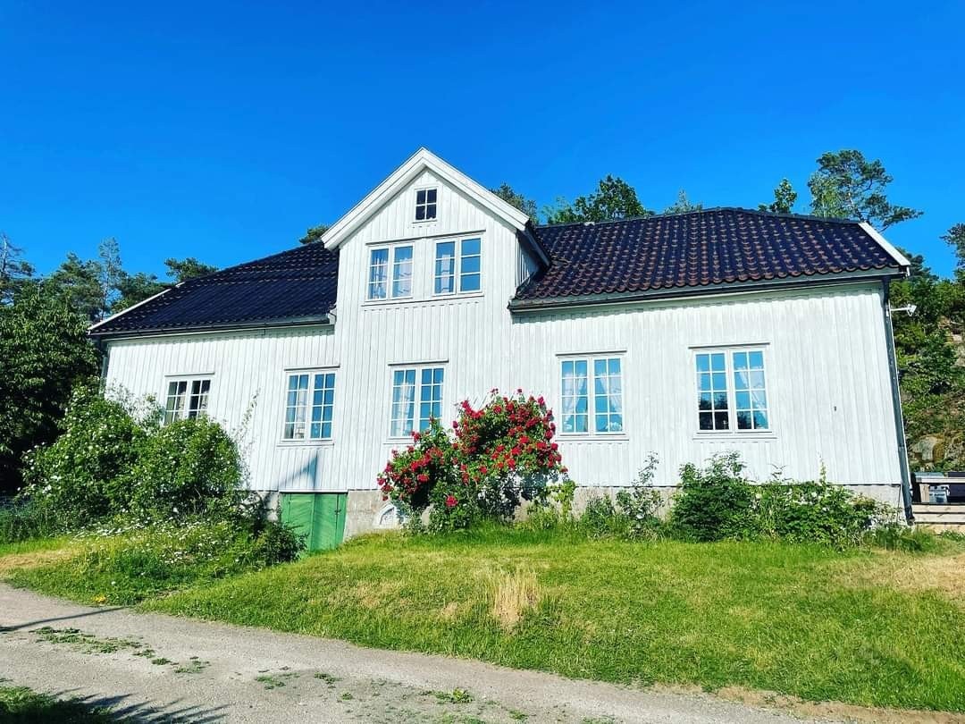 Selgers bilde av hovedhuset med flott rosebed Galleribilde