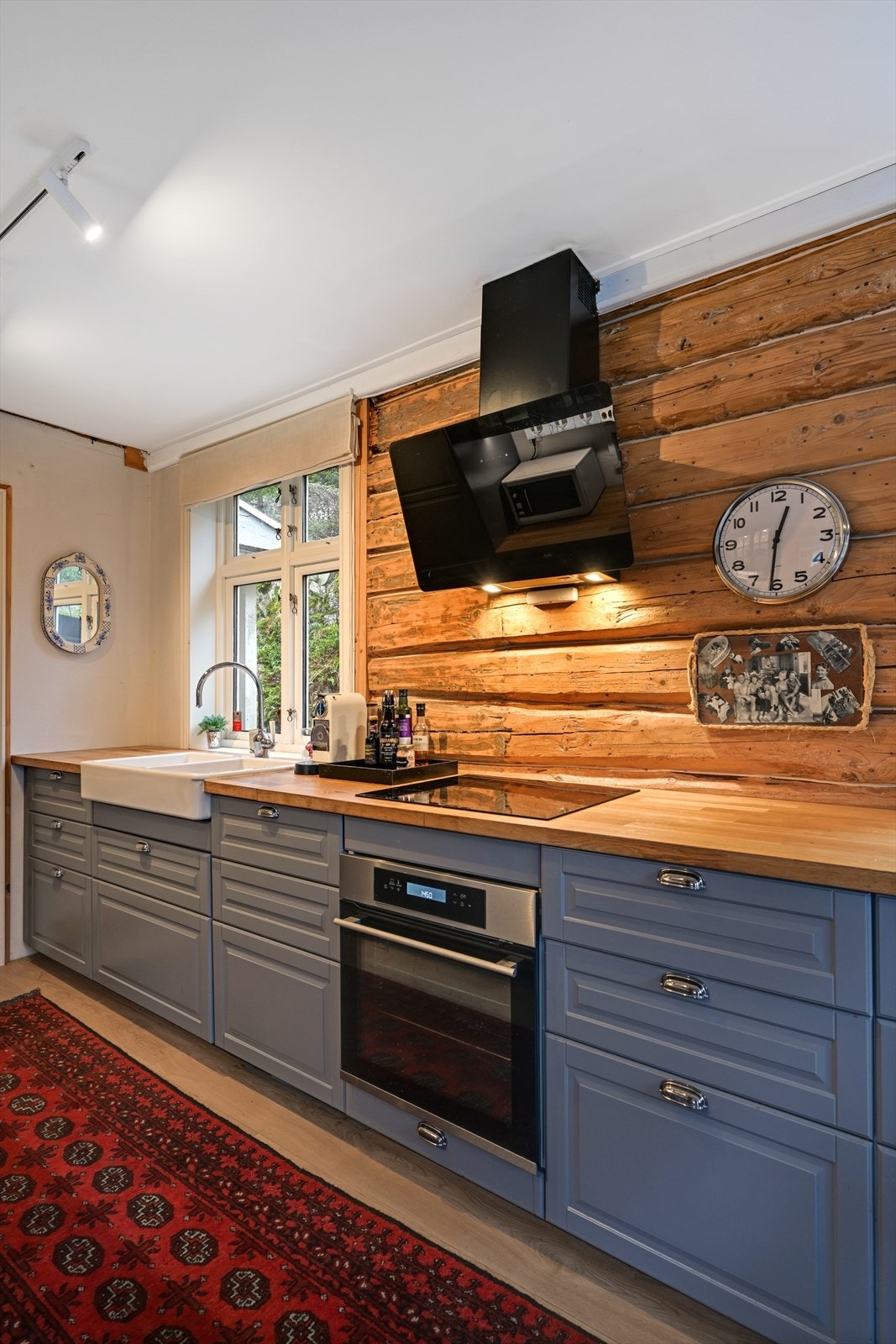 På kjøkkenet er husets naturlige sjarm hentet frem med de originale tømmerveggene. Galleribilde