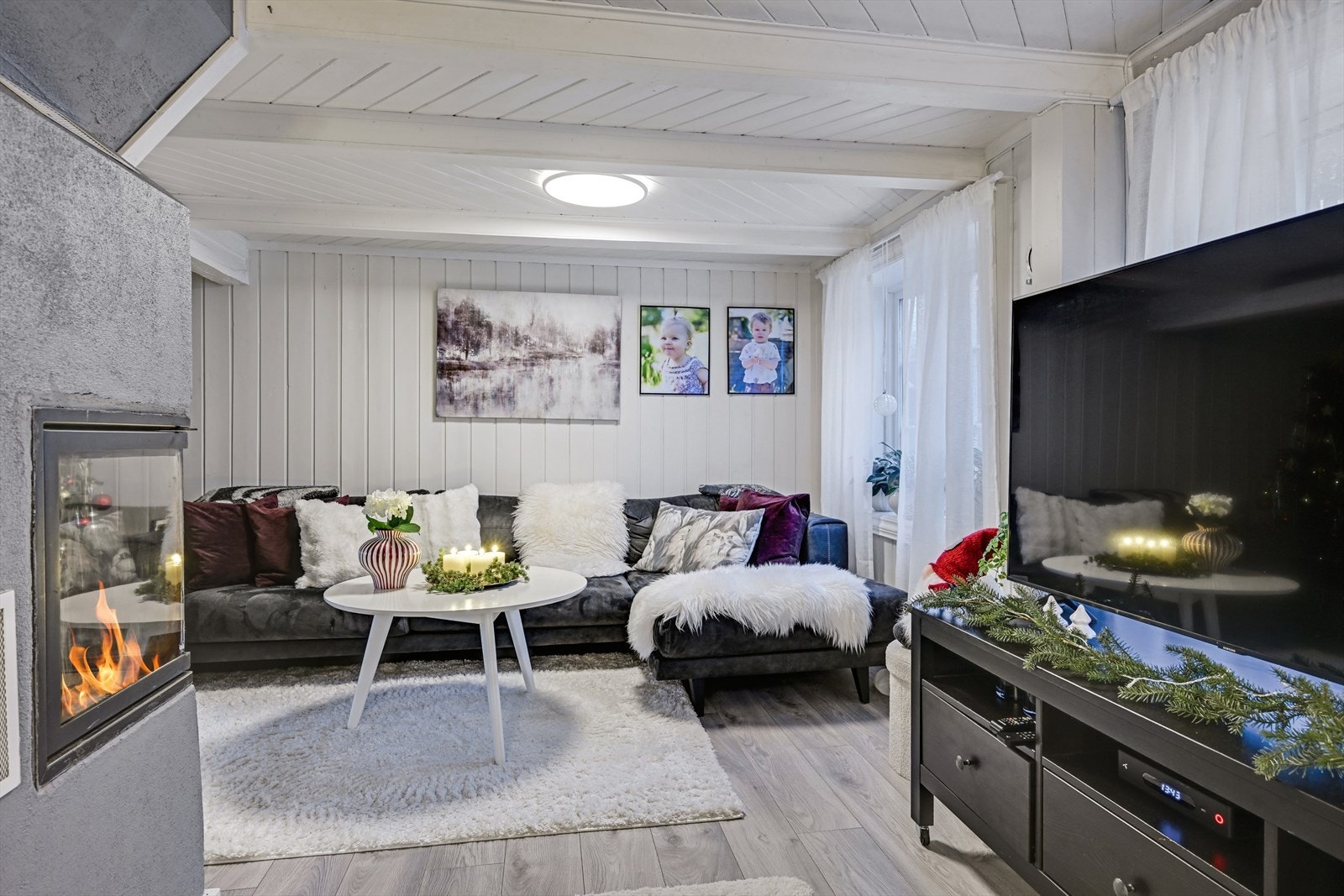 Koselig stue med plassbygget peis med innsats som har innsyn fra to sider. Galleribilde