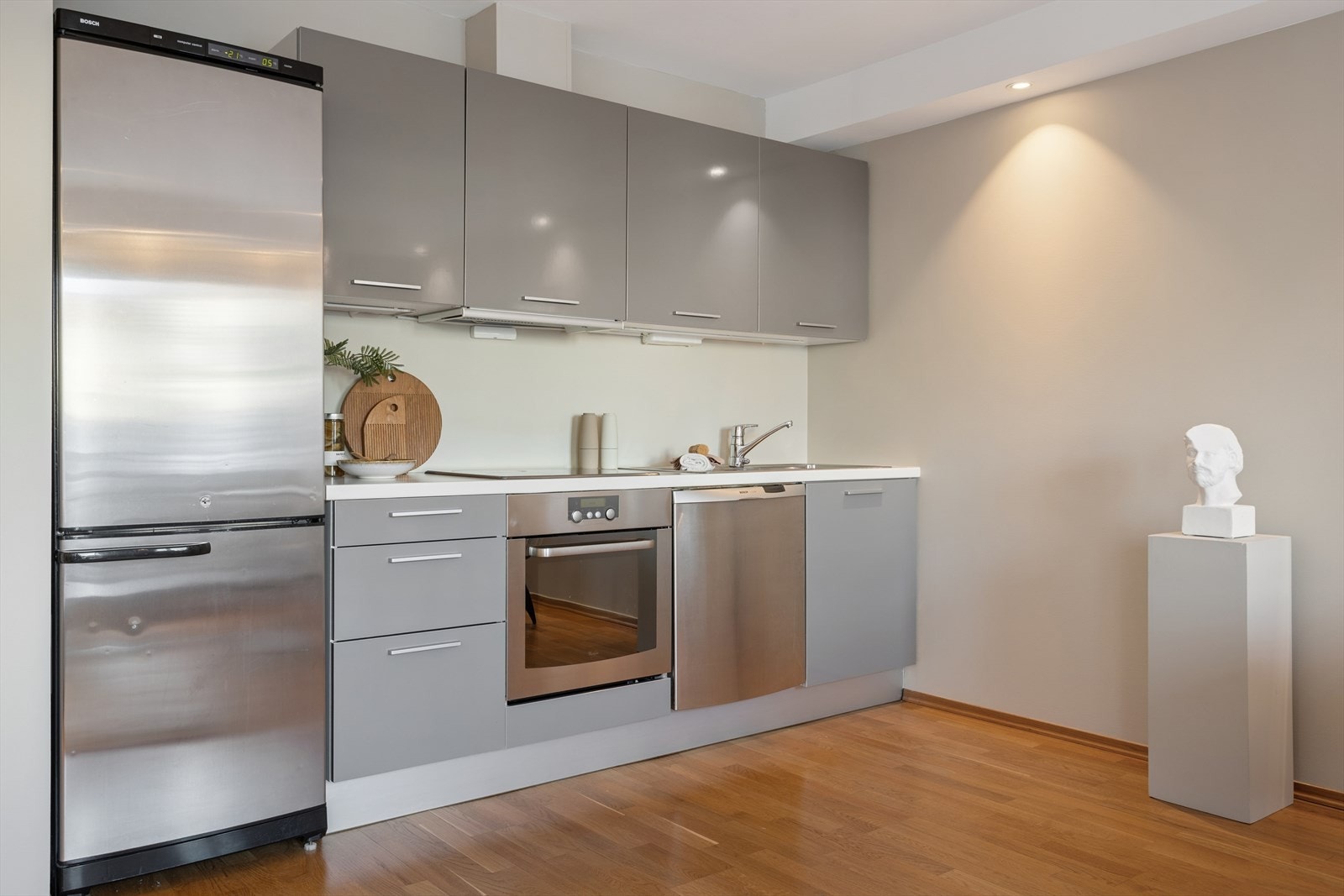 Kjøkkeninnredning med glatte fronter og laminat benkeplate med nedfelt vask. Galleribilde