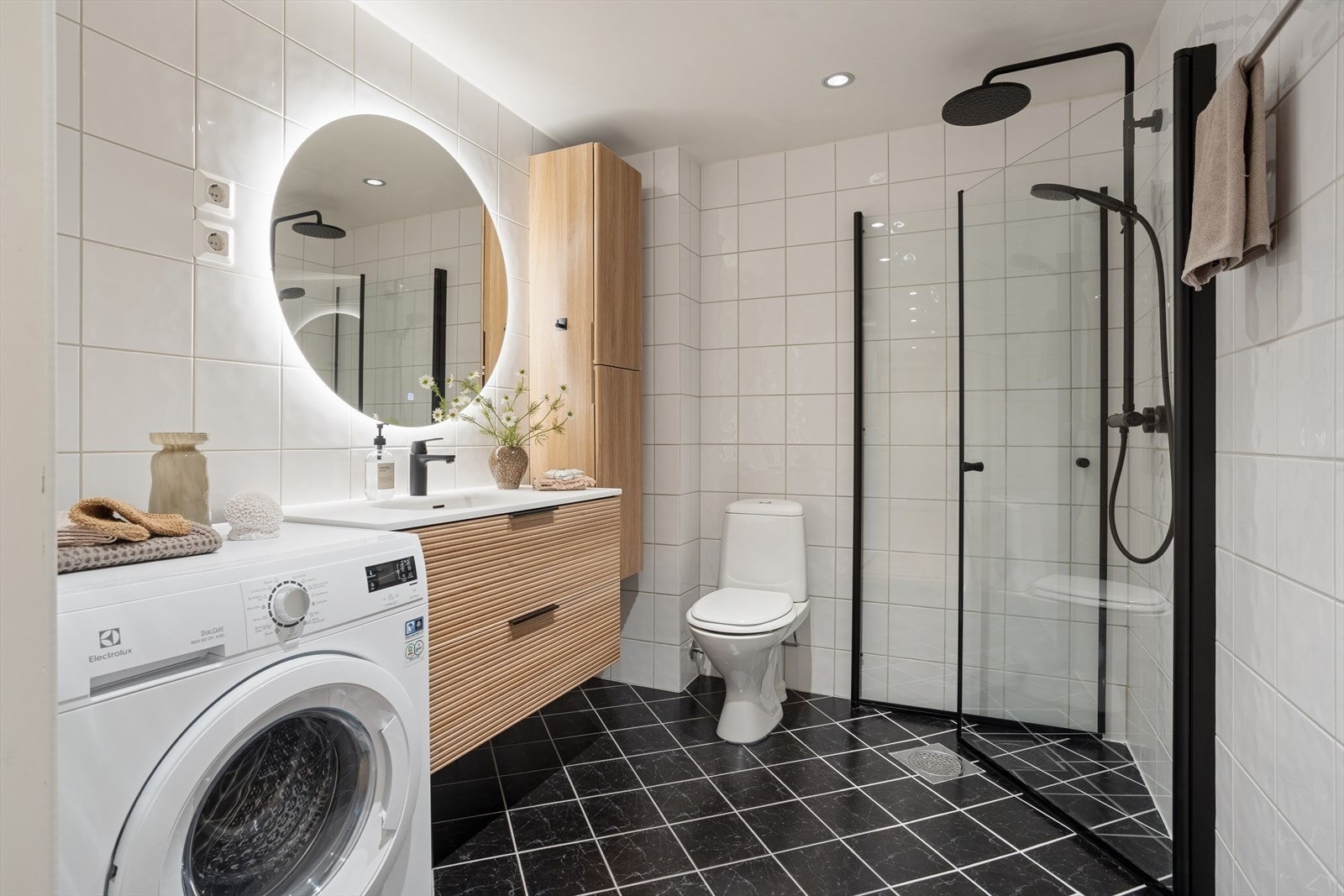 Ny baderomsinnredning fra 2024 med dusjhjørne, gulvstående toalett, servant med underskap og opplegg for vaskemaskin. Galleribilde