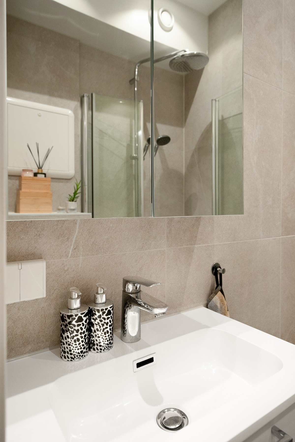 Benkeskap med glatte fronter samt veggskap med speilfronter over servant. Det er opplegg for vaskemaskin på badet. Galleribilde