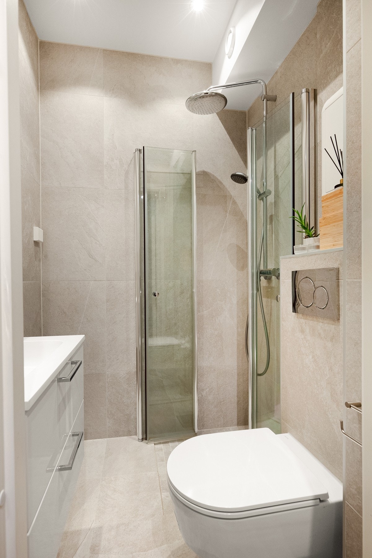 Badet er flislagt med tidsriktige og moderne fliser med nytt støpt gulv med gulvvarme. Dusj på gulv med innfellbare dører i herdet glass, veggfestet toalett med innebygget sisterne. Galleribilde