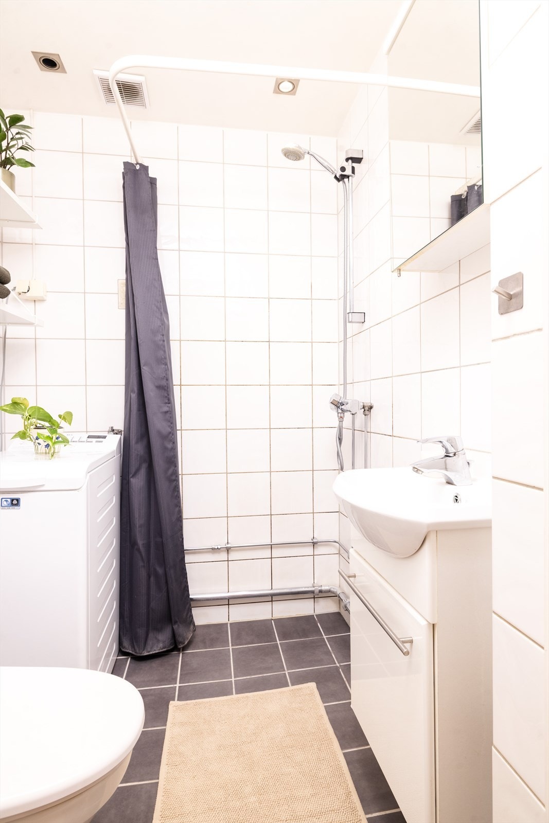 Badet har integrert himlingsbelysning og høyttalere, gulvvarme, dusjhjørne og opplegg for vaskemaskin Galleribilde