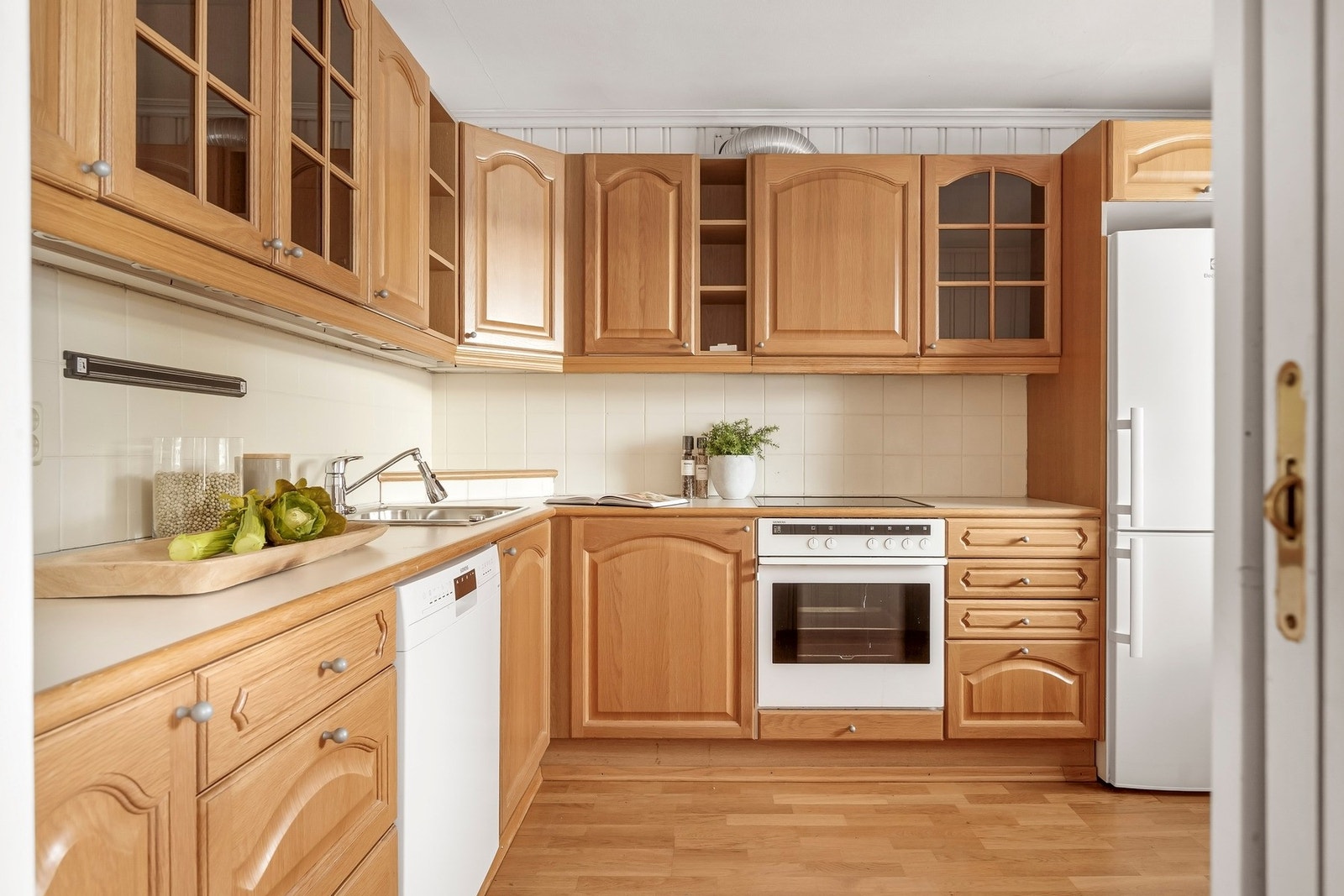 Hvitevarer bestående av integrert platetopp og stekeovn, samt oppvaskmaskin og kjøl-/fryseskap medfølger salget. Galleribilde