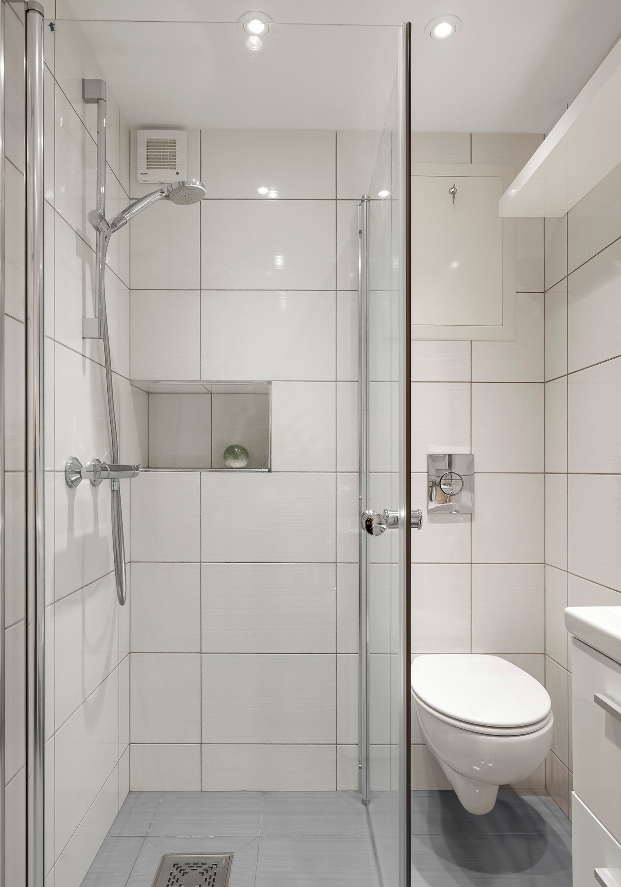 Videre inneholder badet vegghengt toalett og dusjhjørne med innfellbare glassdører. Galleribilde