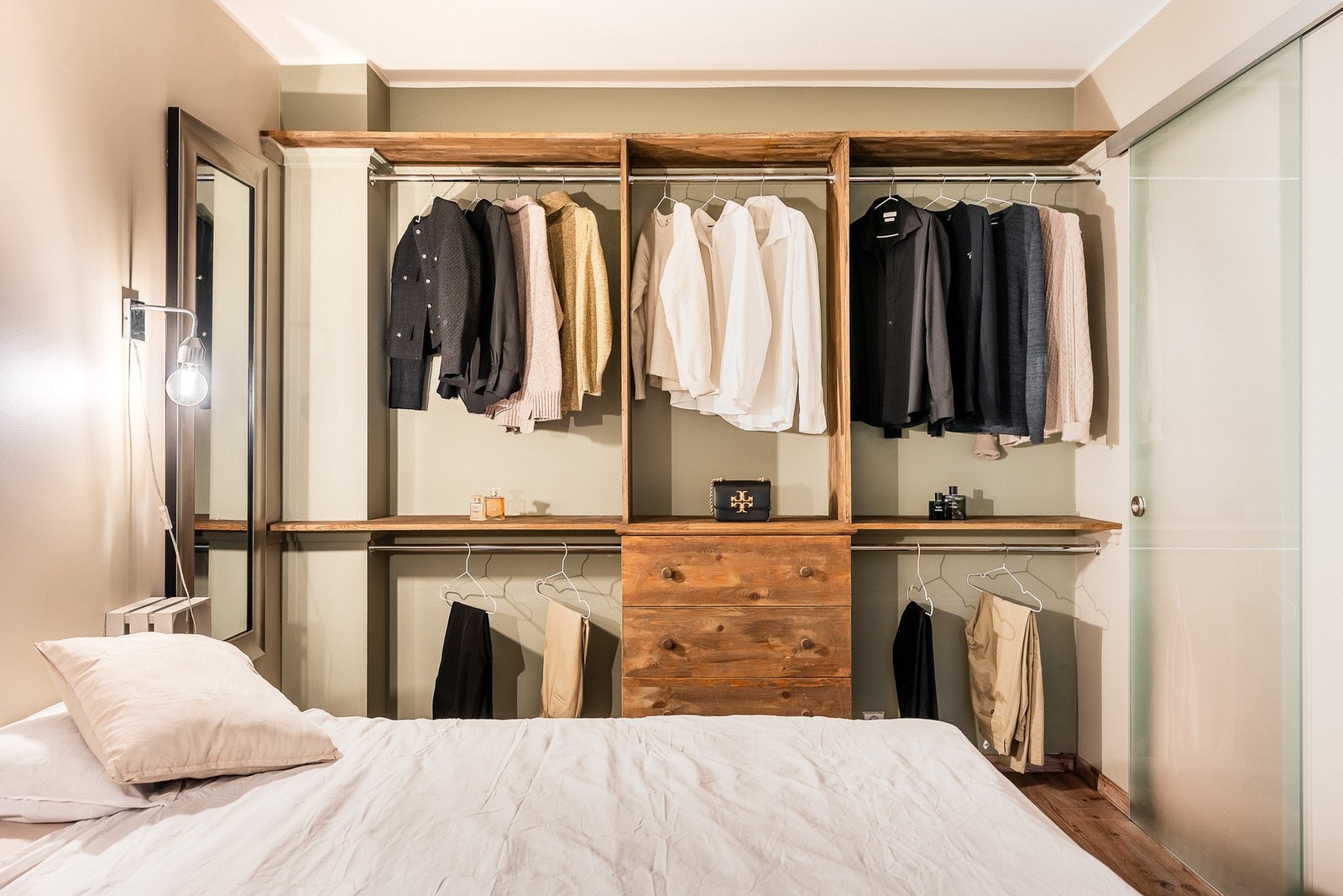 Langs den ene veggen har soverommet en smart garderobeløsning, med skuffer, store hyller og klesoppheng i ulike høyder. Galleribilde