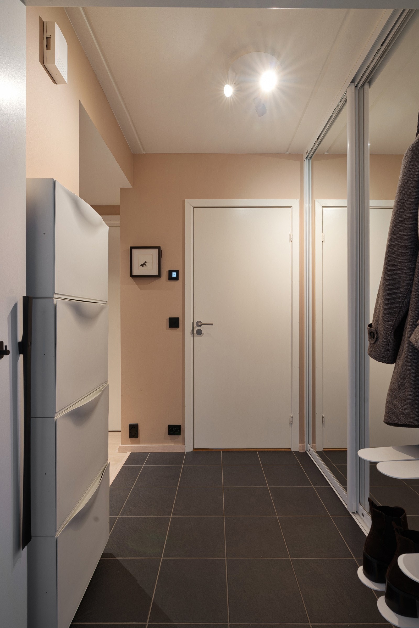 Flislagt entrè med smarte oppbevaringsløsninger med skoskap, skyvedørsgarderobe etc. Galleribilde