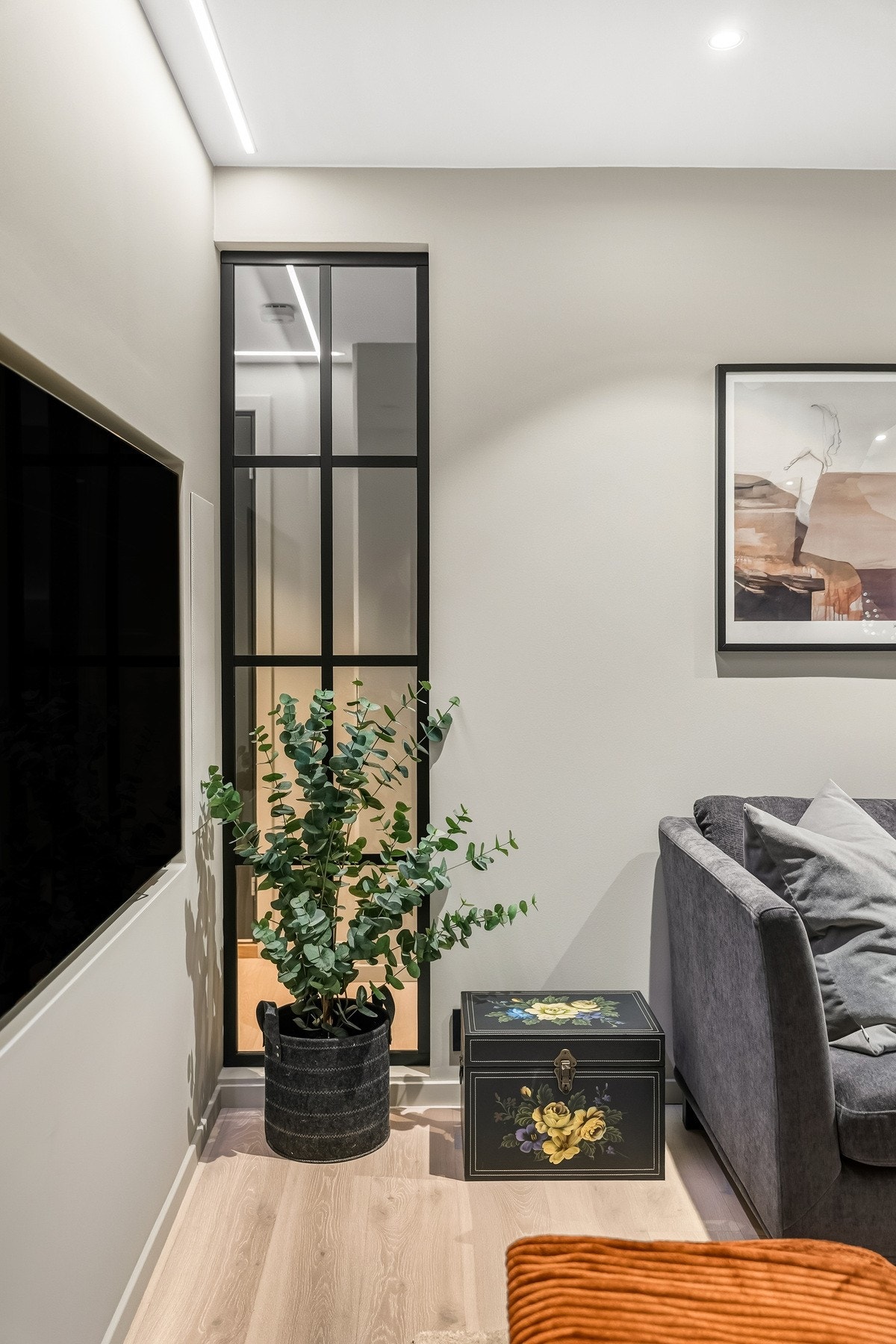 Midt i bildet ser man glass som er satt inn mellom stue og gang. En fin detalje og også gir ekstra lys inn til gangen. Tv til venstre i bilder følger salget. Det er også opplegg for 6 høytalere i leiligheten. Galleribilde