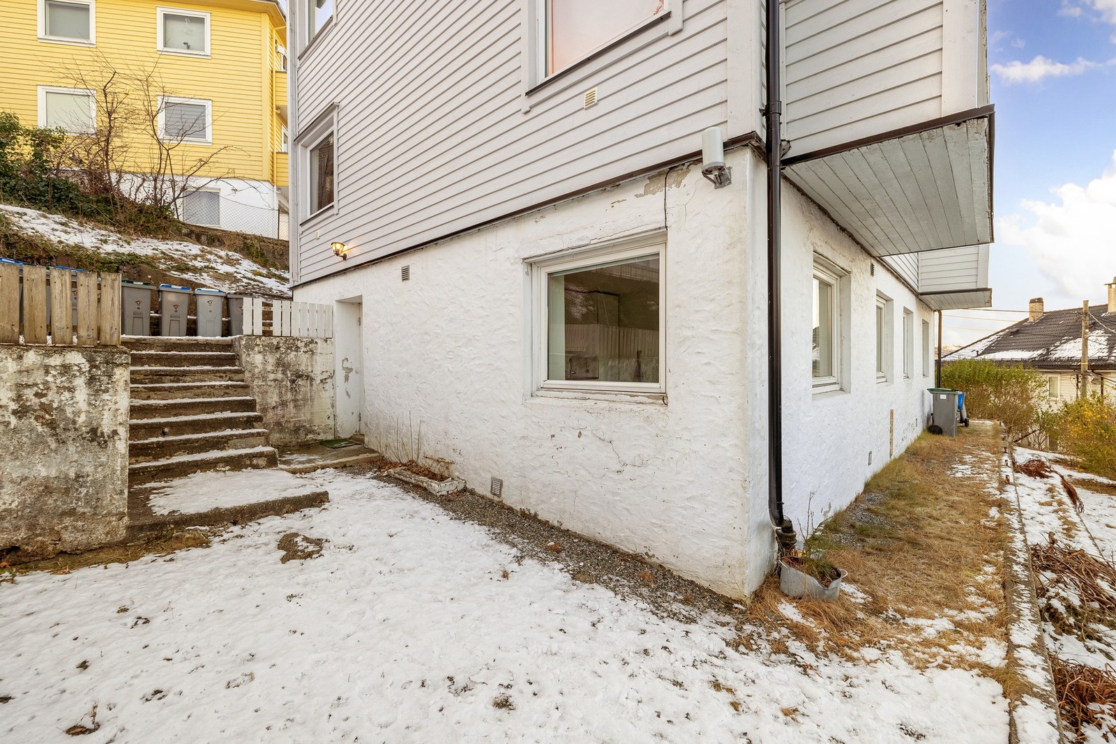 Leiligheten har et eget inngangsparti på siden hvor det også er en gruset uteplass som er felles for sameiet. Galleribilde