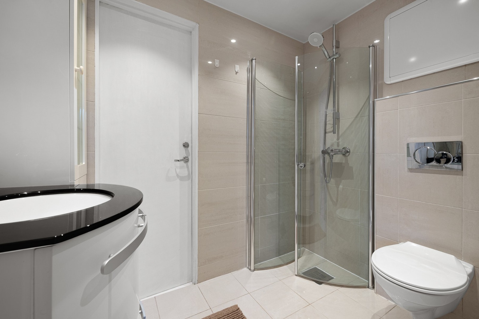 Badet måles til 3,2 kvm. og er helfliset med underliggende varmekabler og innfelte downlights i himling. Galleribilde