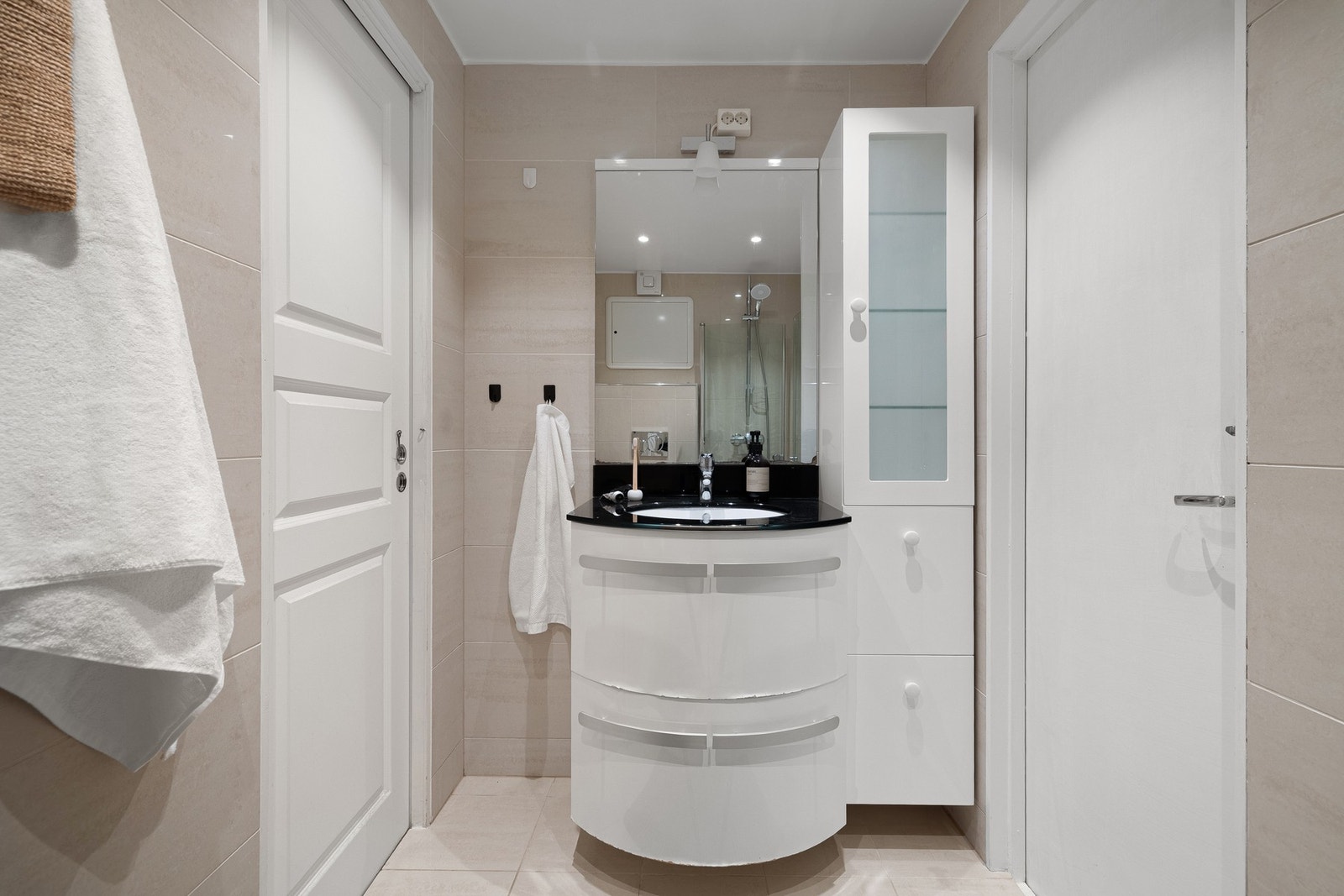 Det er innredet med vegghengt toalett, dusj med glassvegger og baderomsinnredning med speil og belysning. Galleribilde