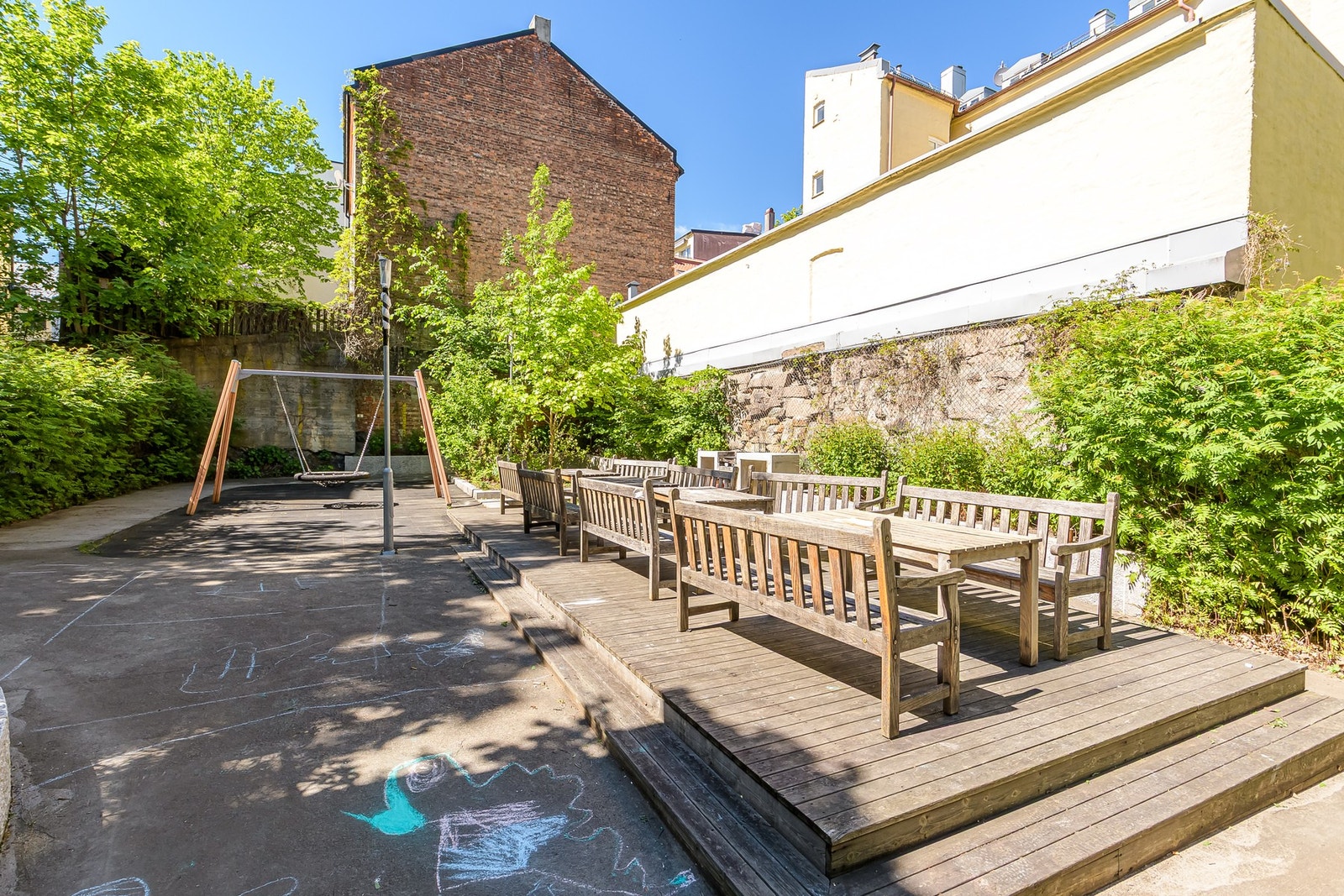 Innbydende bomiljø med lekeplass og sittebenker - godt tilrettelagt for både store og små Galleribilde