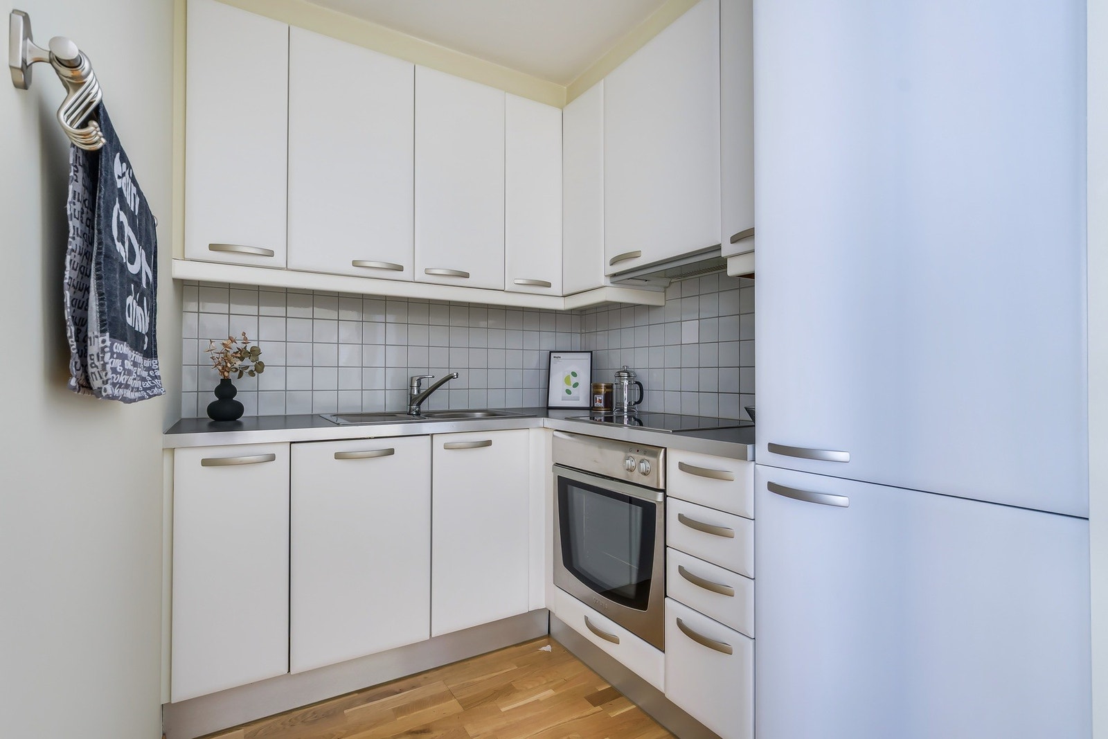 Kjøkken med glatte fronter, laminert benkeplate med integrert kjøkkenkum og
flislagt vegg over kjøkkenbenk! Galleribilde