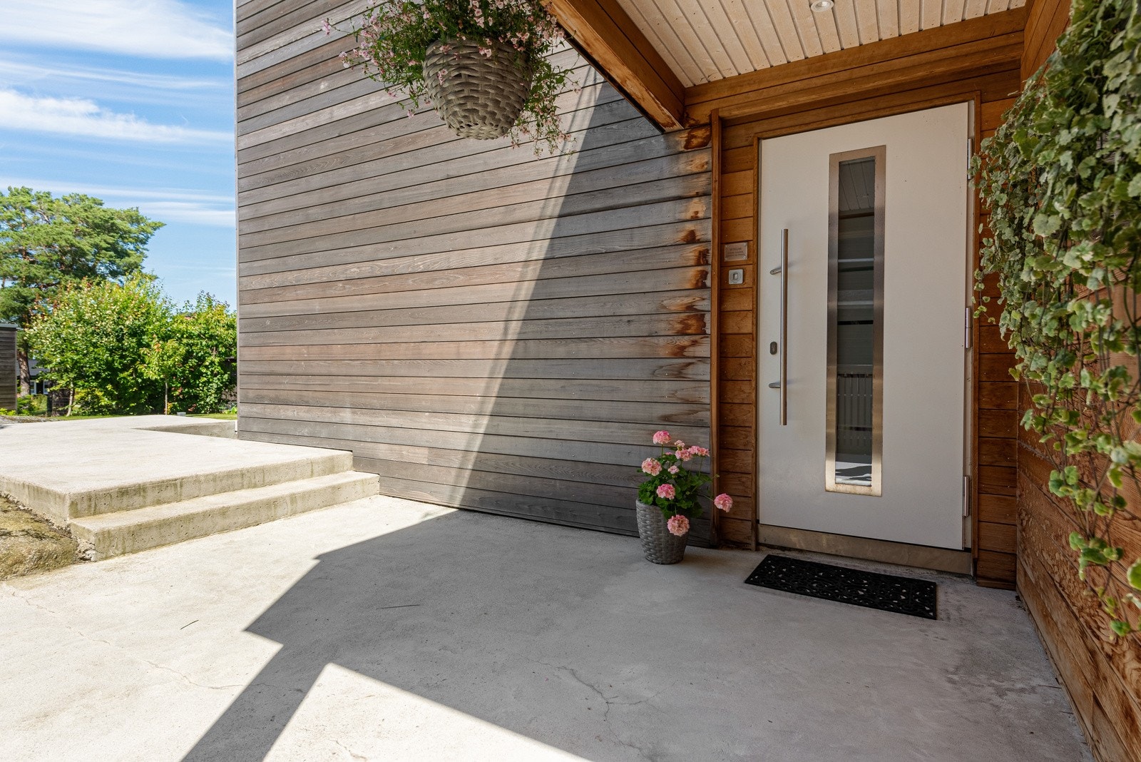 Pen og ryddig inngang til boligen via terrasse i mur. Det er fingerscanning på dørlås på ytterdøren Galleribilde