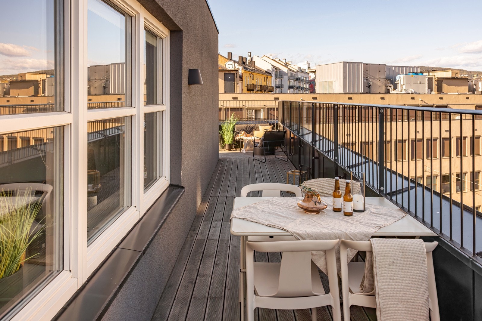 Terrassen har terrassebord på gulv og utebelysning montert på vegg. Galleribilde