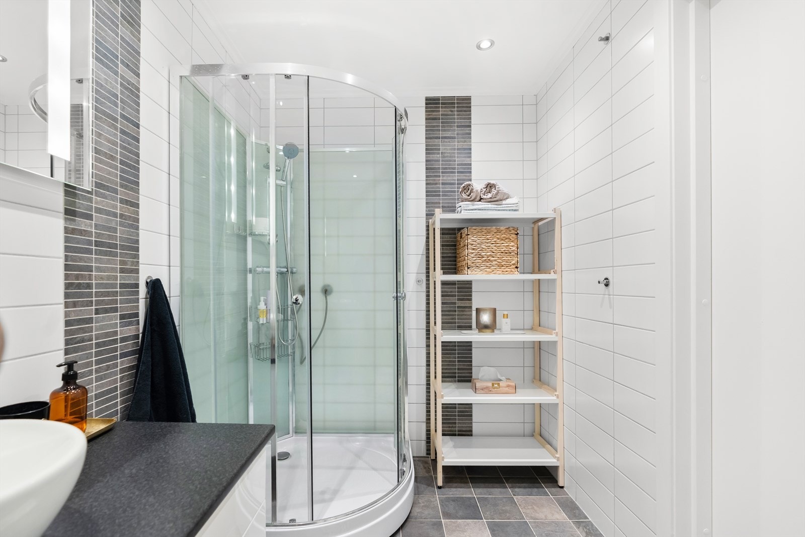 Innredningen består av vegghengt servantskap med skuffer, speil med belysning, dusjhjørne og toalett. Galleribilde