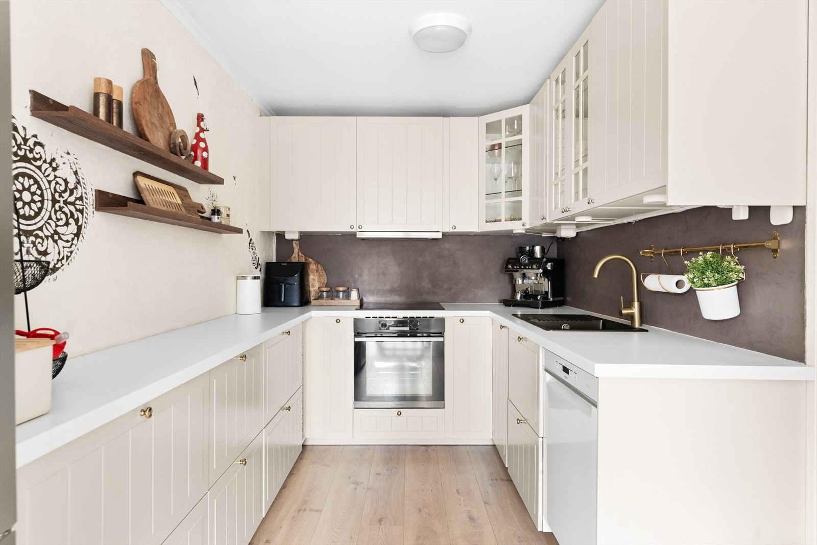 Stilren kjøkkeninnredning fra 2022. Innredningen består av lyse profilerte fronter og laminat benkeplate med nedfelt kum. Galleribilde