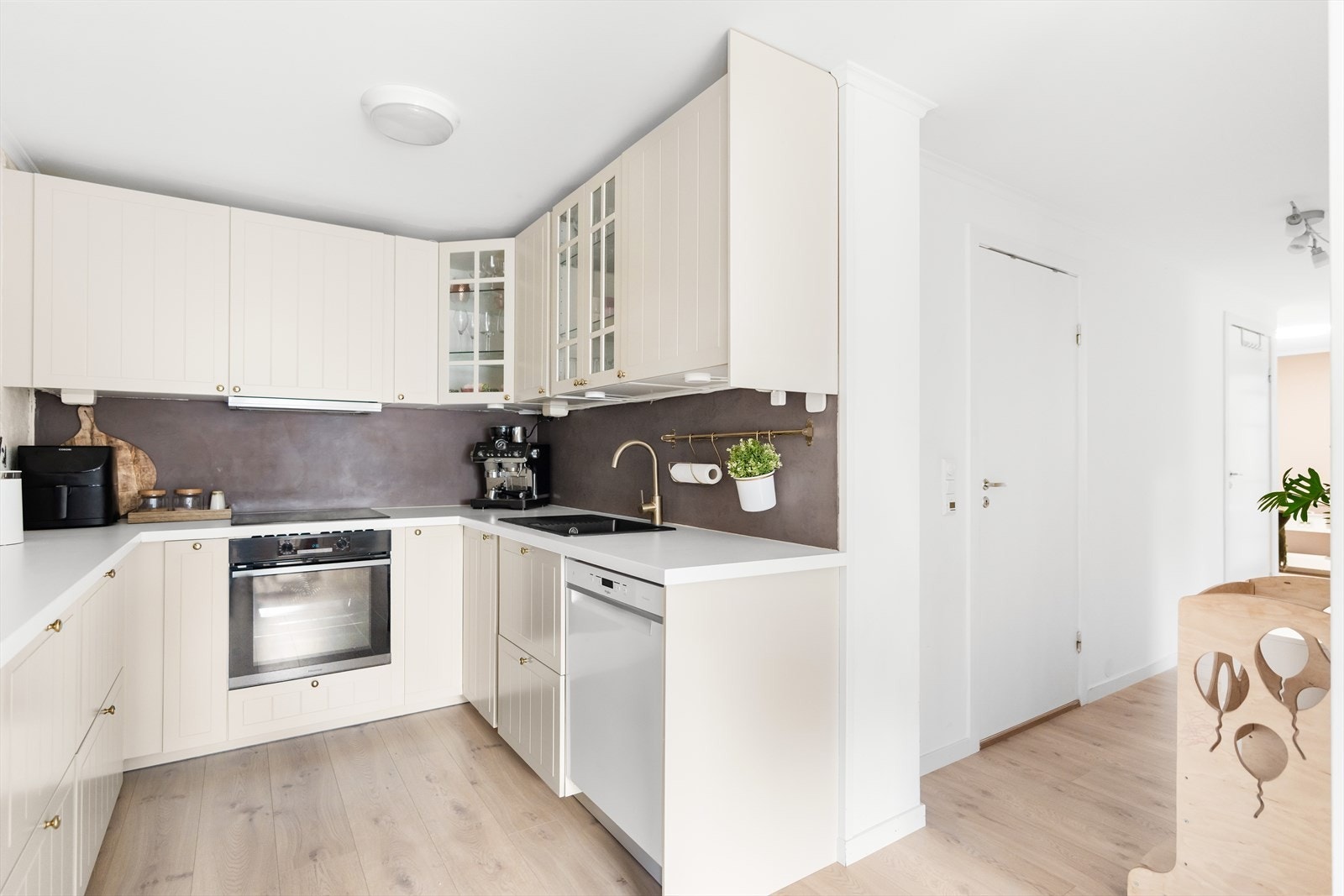 Belysning under overskap. De integrerte hvitevarene inkluderer platetopp, stekeovn og oppvaskmaskin. Boligen har en egen spisestue tilknyttet kjøkkenet. Galleribilde