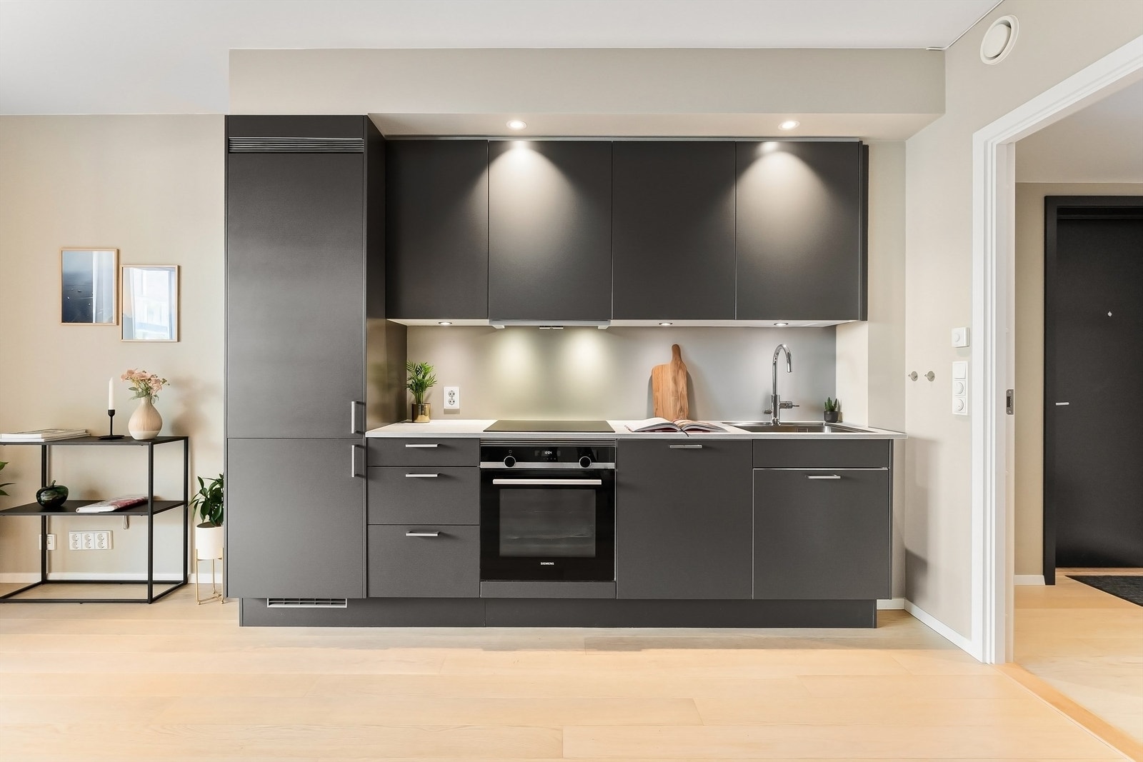 Kjøkkenet er utstyrt med integrerte hvitevarer: kjøleskap med frysedel, komfyr, nedfelt platetopp og oppvaskmaskin Galleribilde