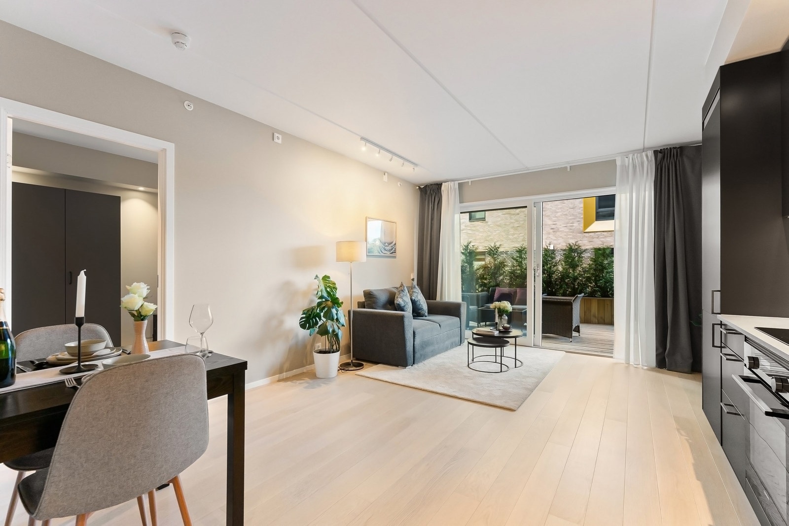 Stuen er lys og luftig med åpen løsning mot et lekkert og stilrent kjøkken Galleribilde