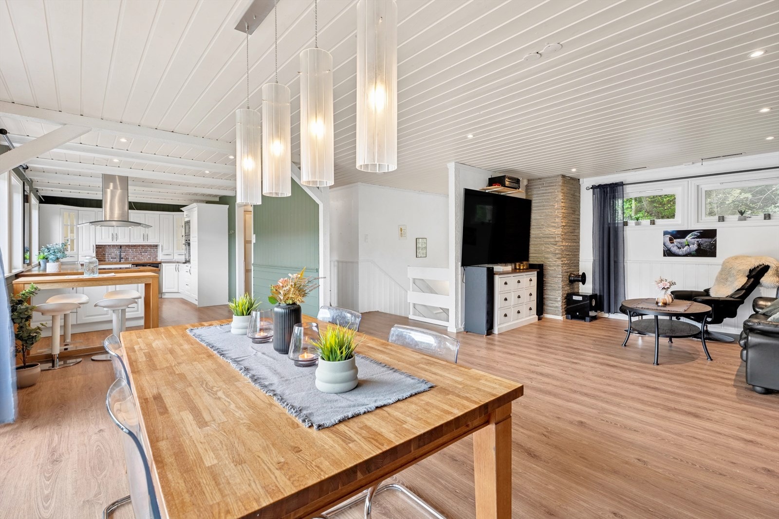 Den åpne løsningen mellom stue og kjøkken gir en sosial og praktisk sone for både hverdagsliv og gjestfrihet. Galleribilde