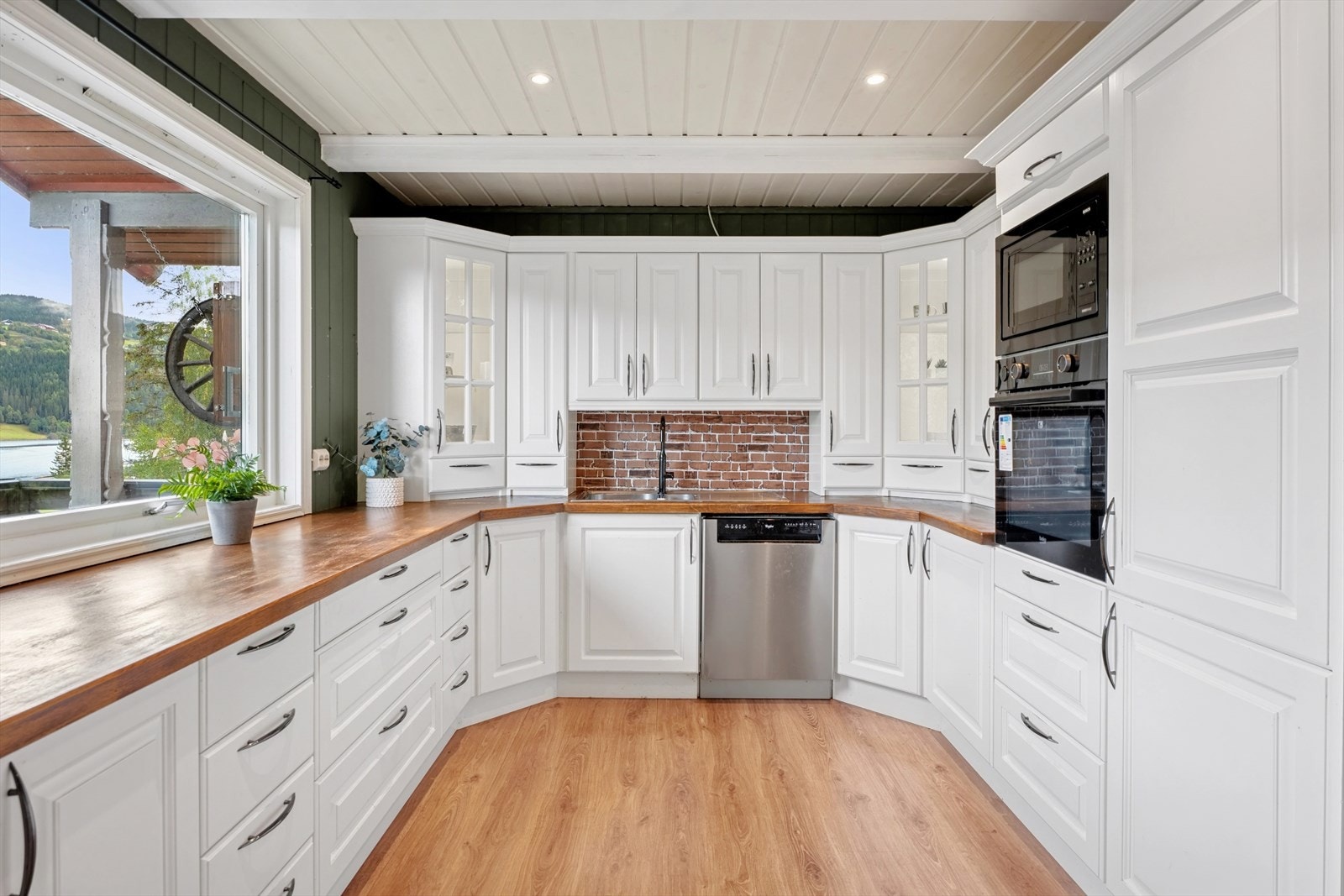 Kjøkkenet har en klassisk innredning fra 2016 med malte profilerte fronter, benker og skap. Galleribilde