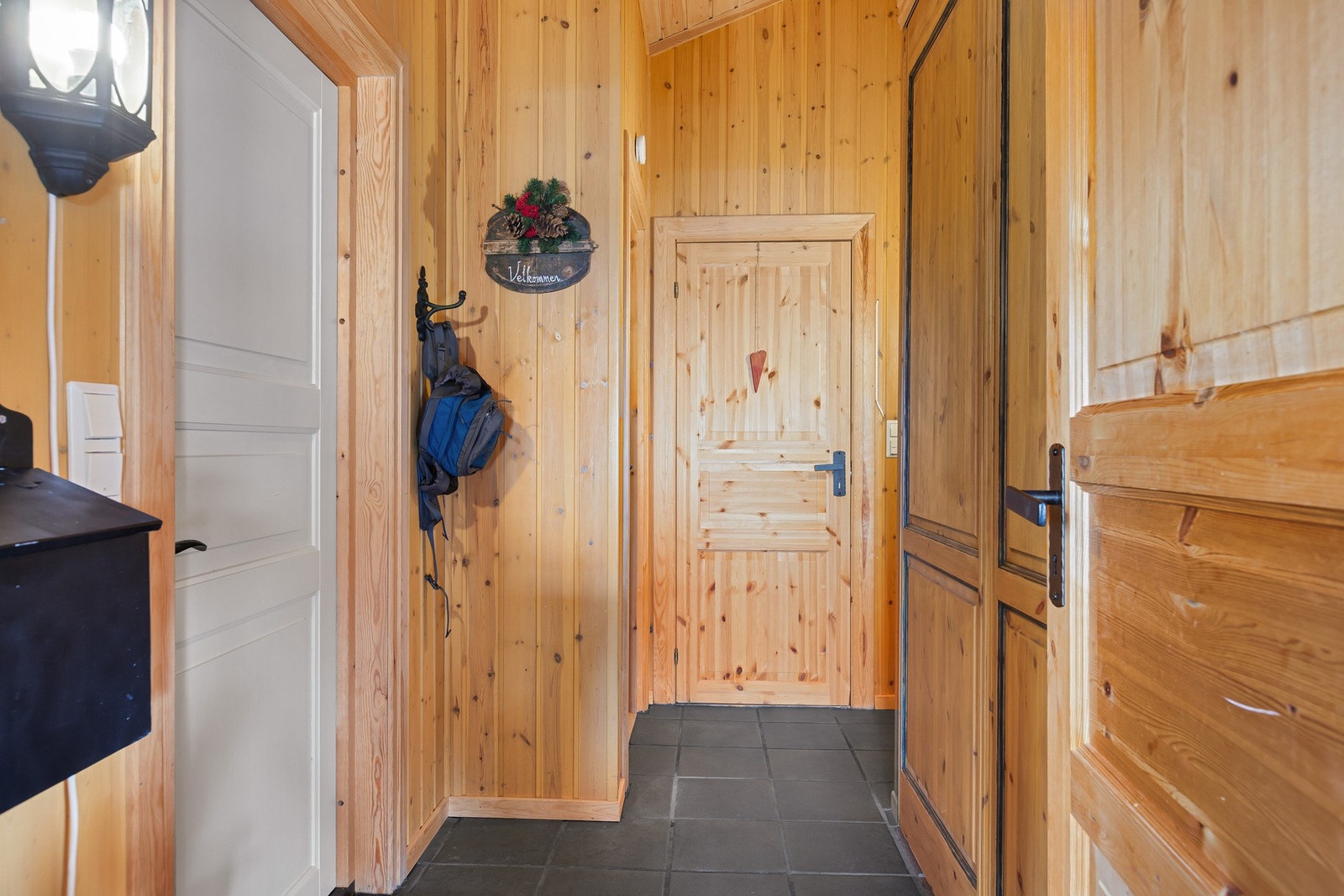 Gang med varme i gulv, innredet med praktisk garderobe med plass til å henge fra seg yttertøy. Galleribilde