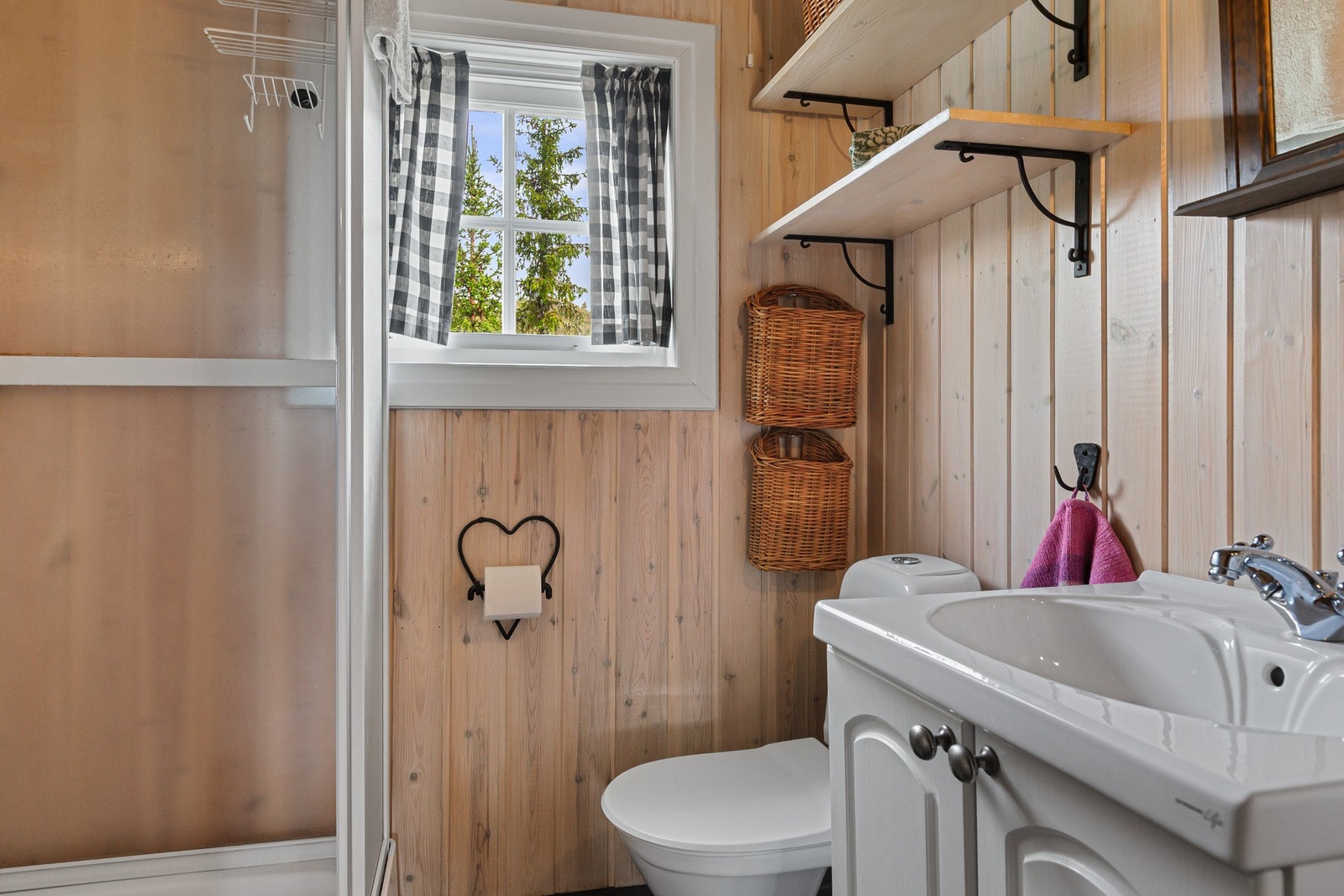 Bad innredet med servant med underskap, dusjkabinett, gulvmontert toalett. Galleribilde