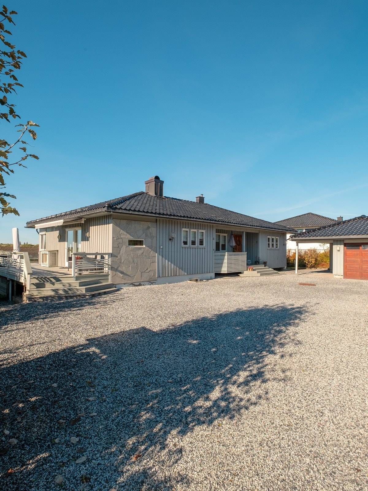 Parkering kan gjøres i den frittliggende garasjen, i carporten eller på den store, gruslagte gårdsplassen. Galleribilde