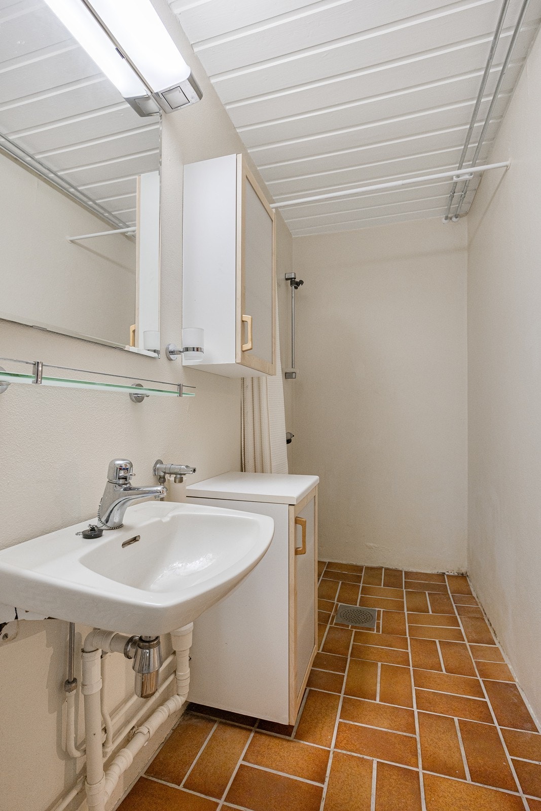 Innredningen består av servant, speil, over- og underskap. Videre har badet toalett og dusjhjørne. Galleribilde