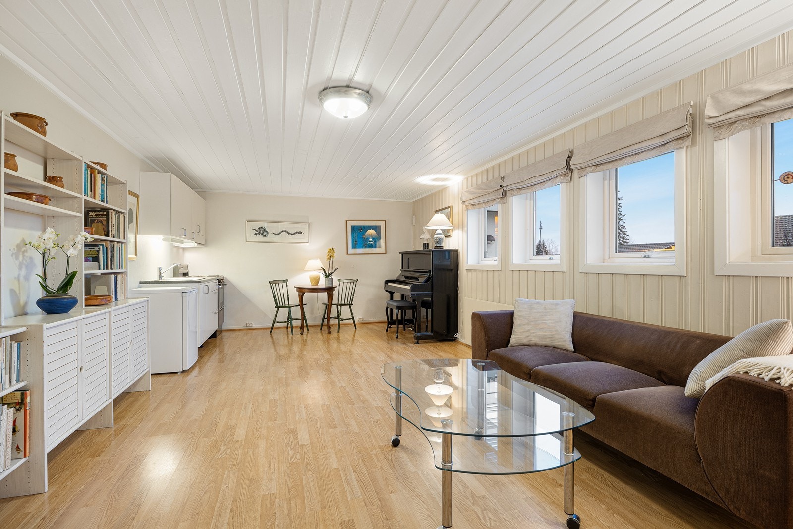 Allrommet som utgjør stue og kjøkken har lysmalte vegger og gyllent gulv, og det er fin plass til sofagruppe, tv-møblement og spisebord. Galleribilde