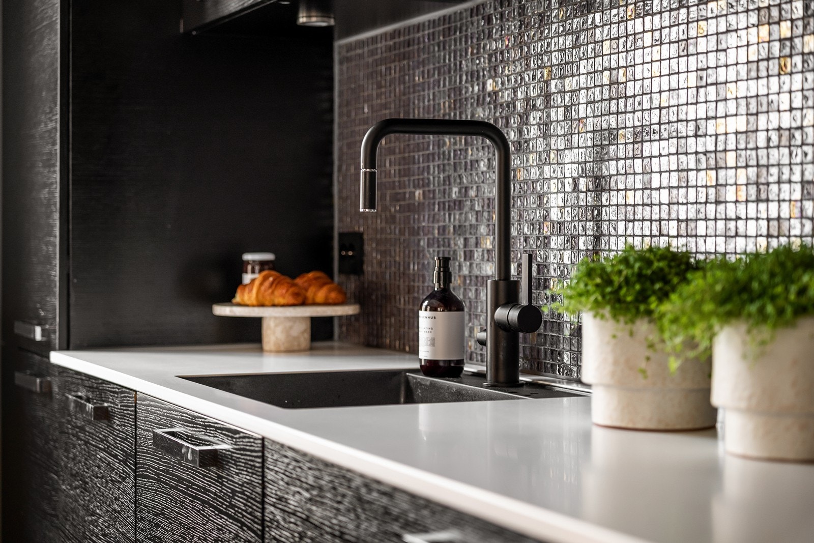 Kjøkkenet fremstår eksklusivt med fliser fra Fired Earth, kombinert med ny benkeplate fra 2021 med nedfelt kum og stilrent Tapwell blandebatteri som gir et moderne uttrykk. Galleribilde