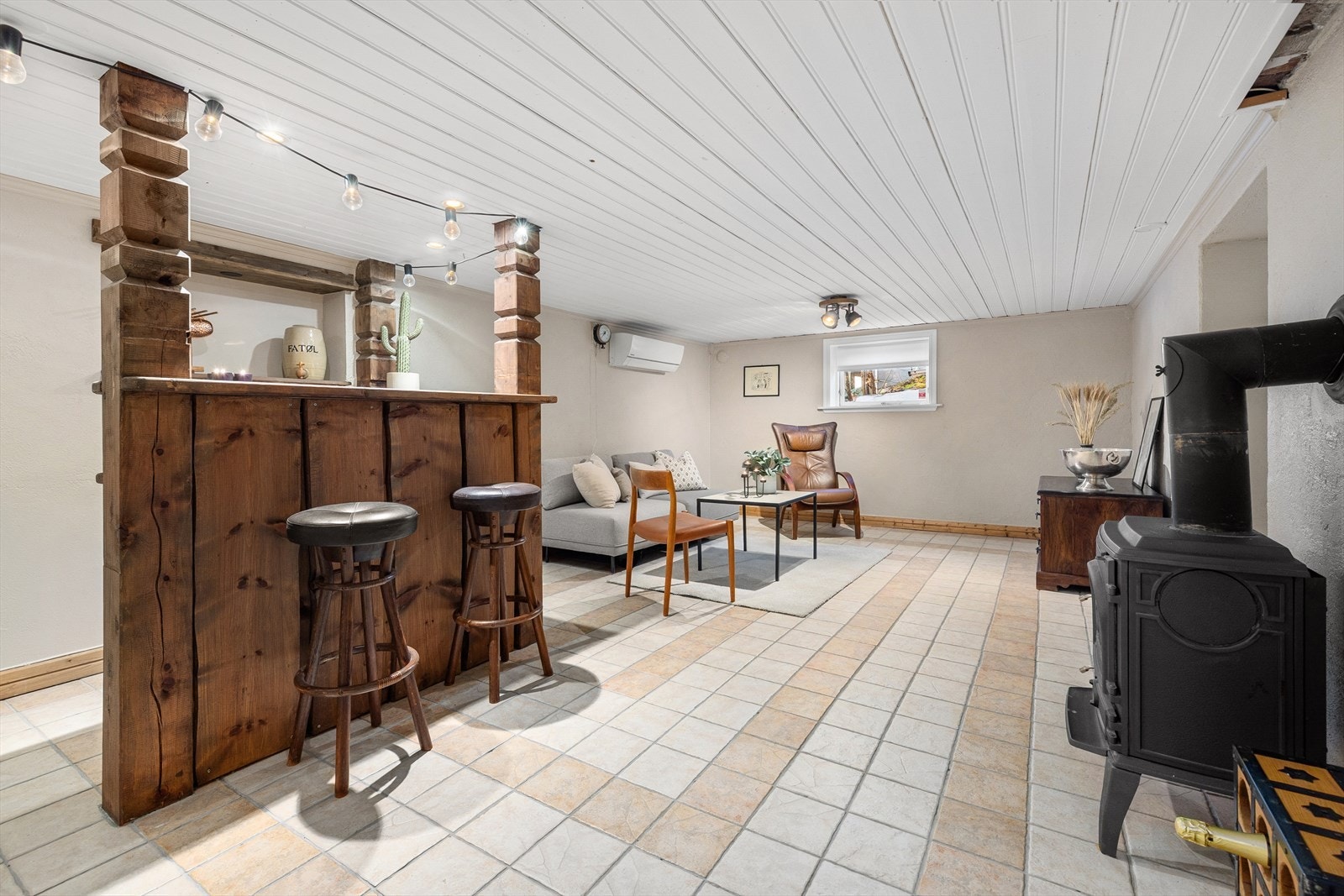 Romslig kjellerstue med vedovn, varmepumpe og behagelige varmekabler i gulv. Galleribilde