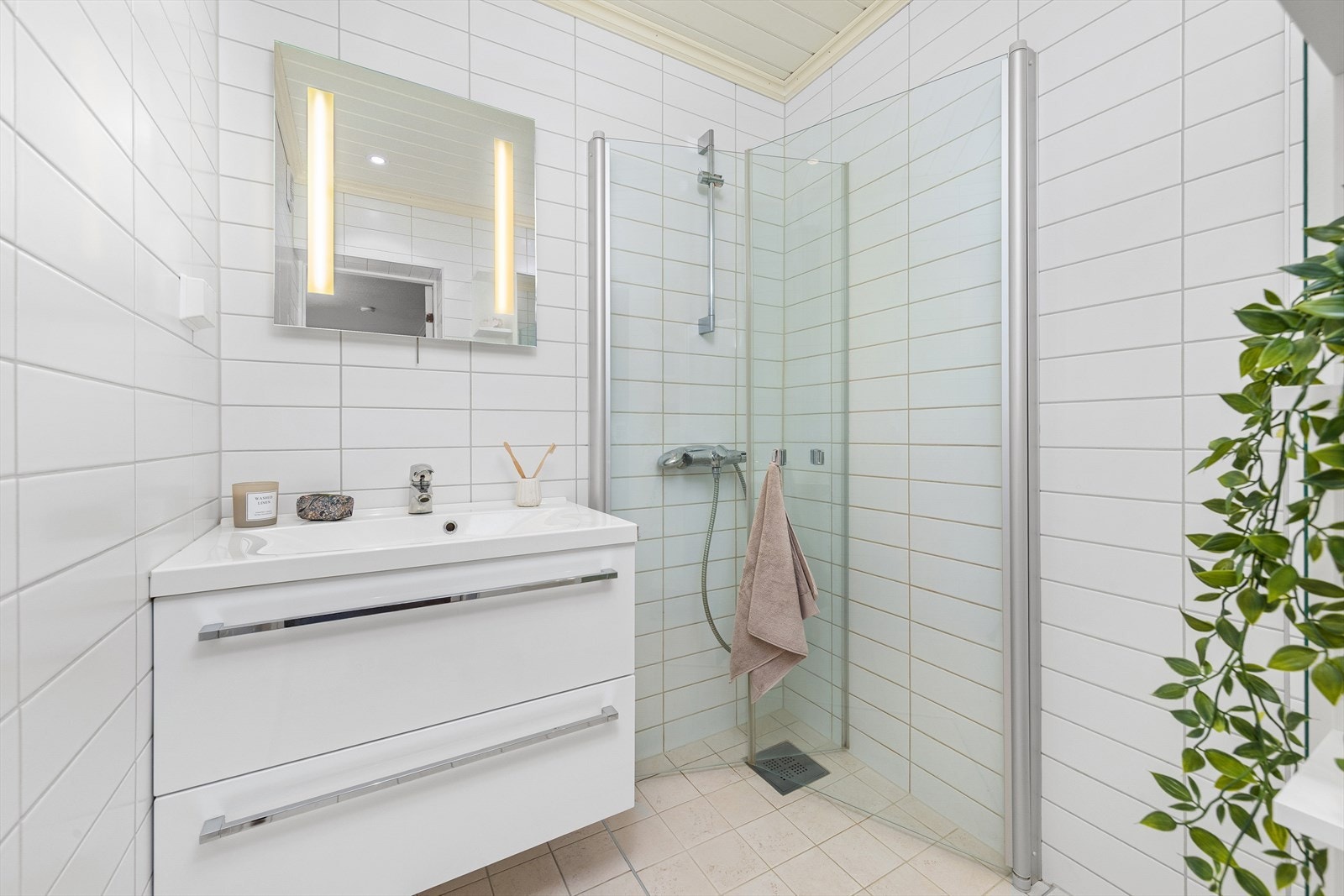 Pent flislagt bad med dusjhjørne og moderne baderomsinnredning. Det er behagelige varmekabler i gulv. Galleribilde