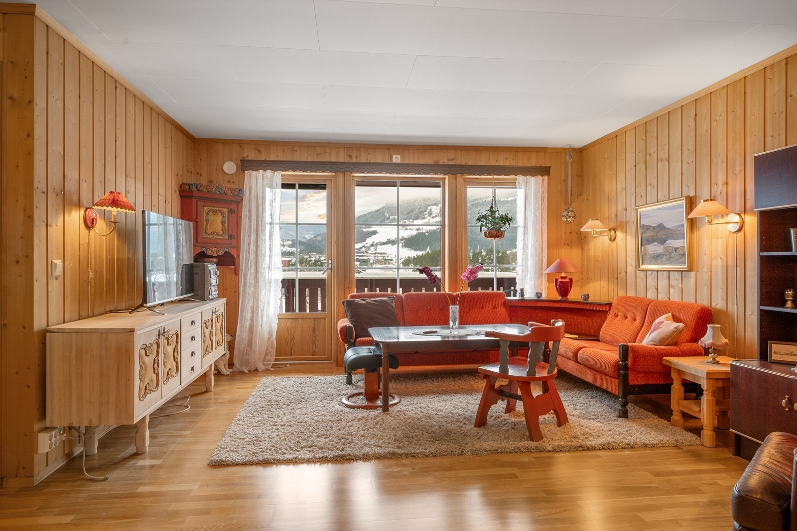 Boligen har en trivelig stue med panelte overflater. Galleribilde