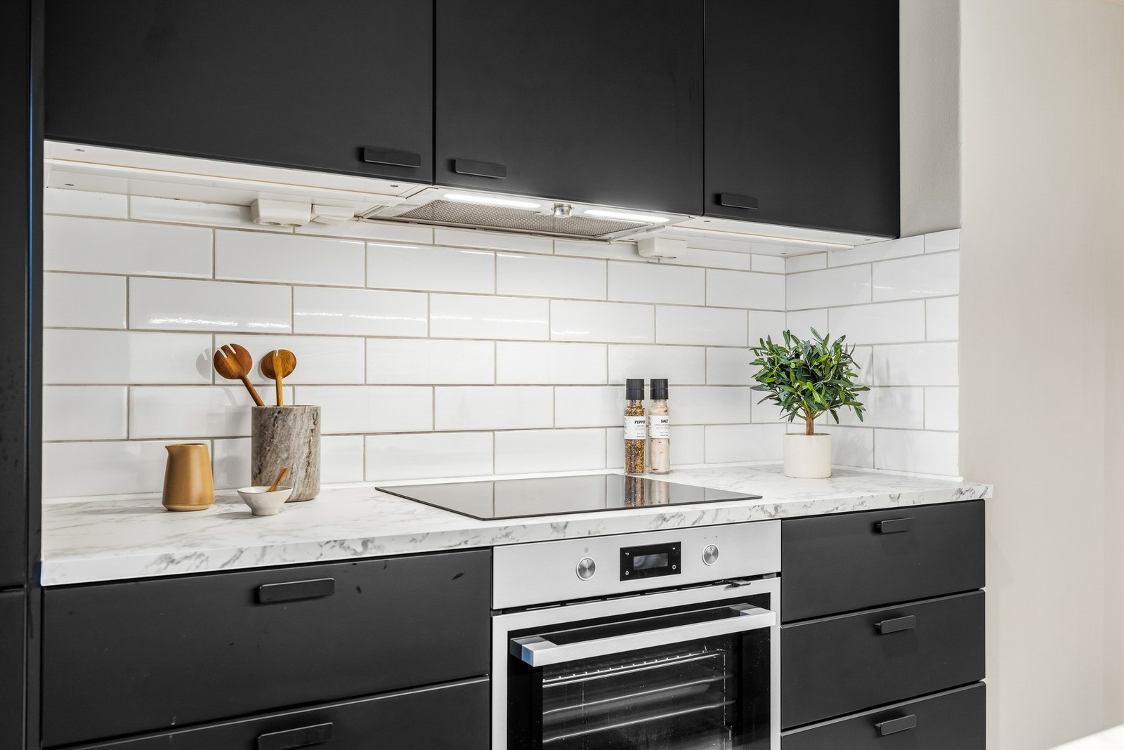 Praktisk kjøkkenløsning med fliser mellom over- og underskap. Galleribilde