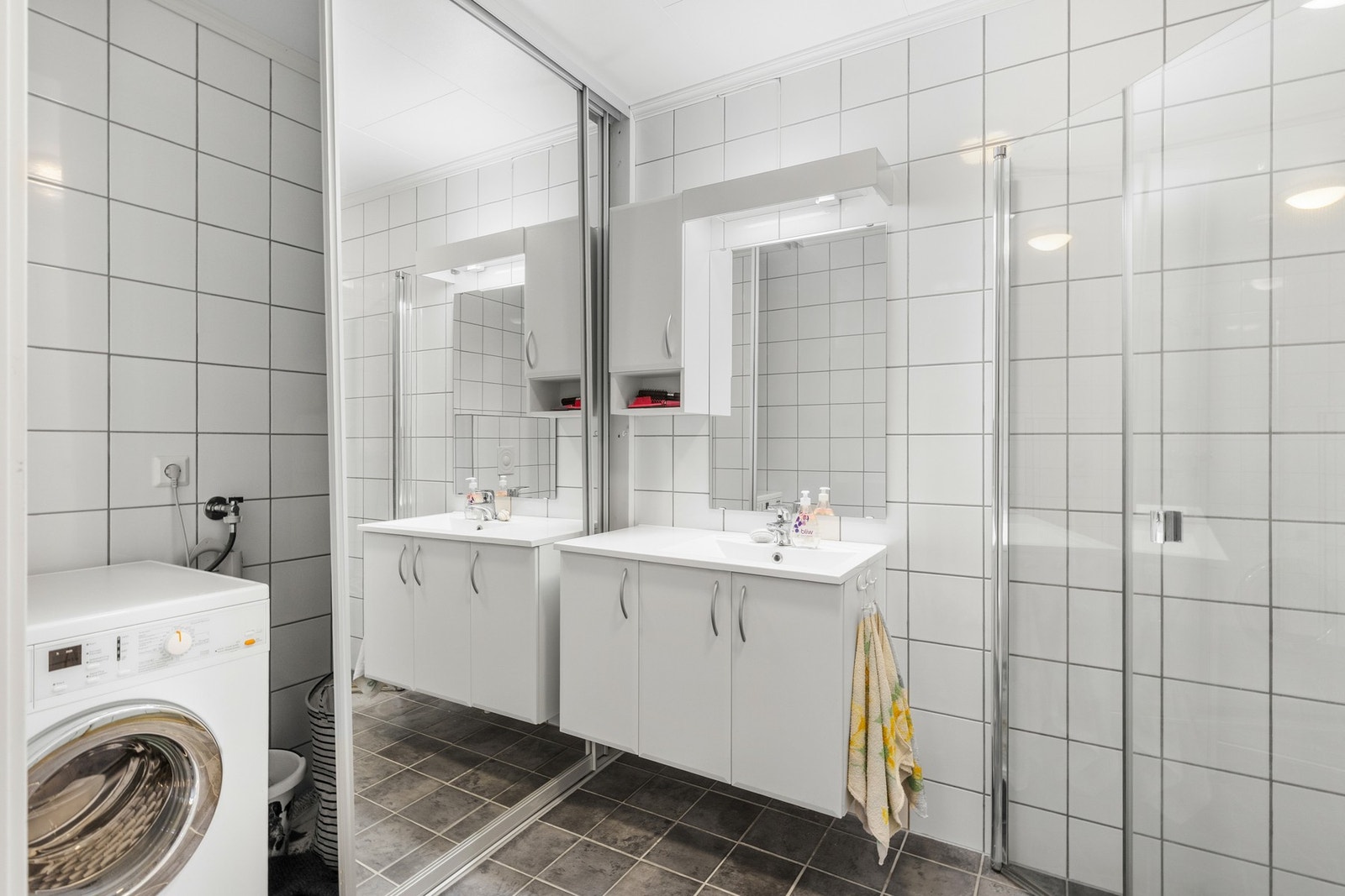 Helfliset bad i første etasje med behagelig gulvvarme. Smart løsning med skyvedør som skjuler vaskemaskinen. Galleribilde