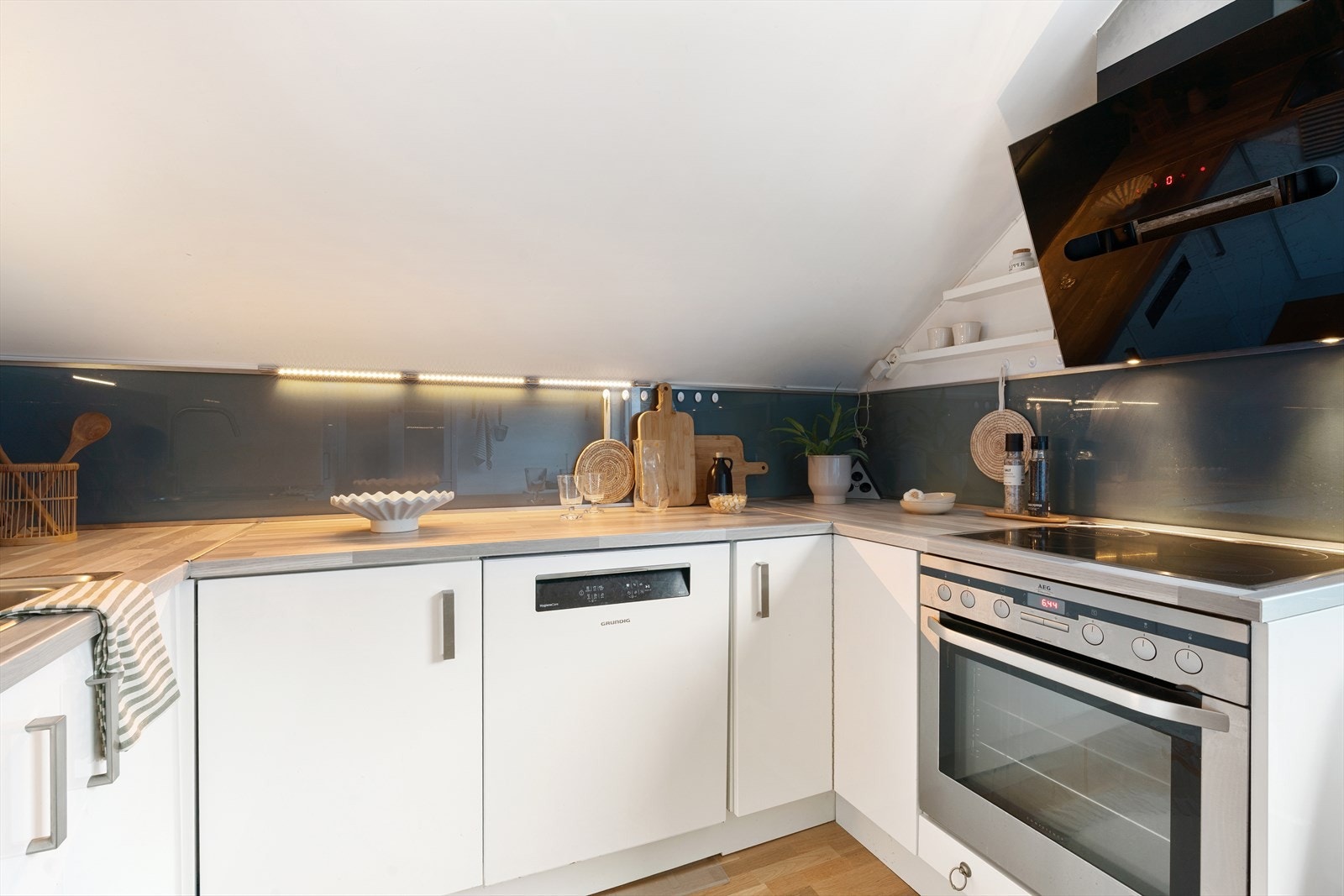 Kjøkkenet er utstyrt med integrerte hvitevarer, inkludert oppvaskmaskin, platetopp og stekeovn, samt et frittstående kjøleskap Galleribilde