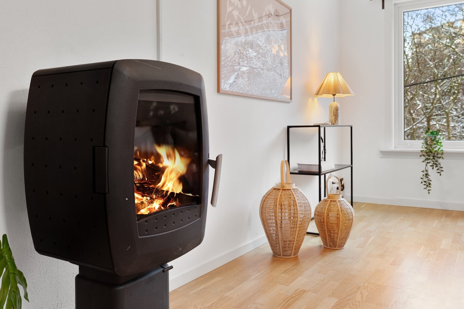 Koselig stue med vedovn og stort vindu Galleribilde