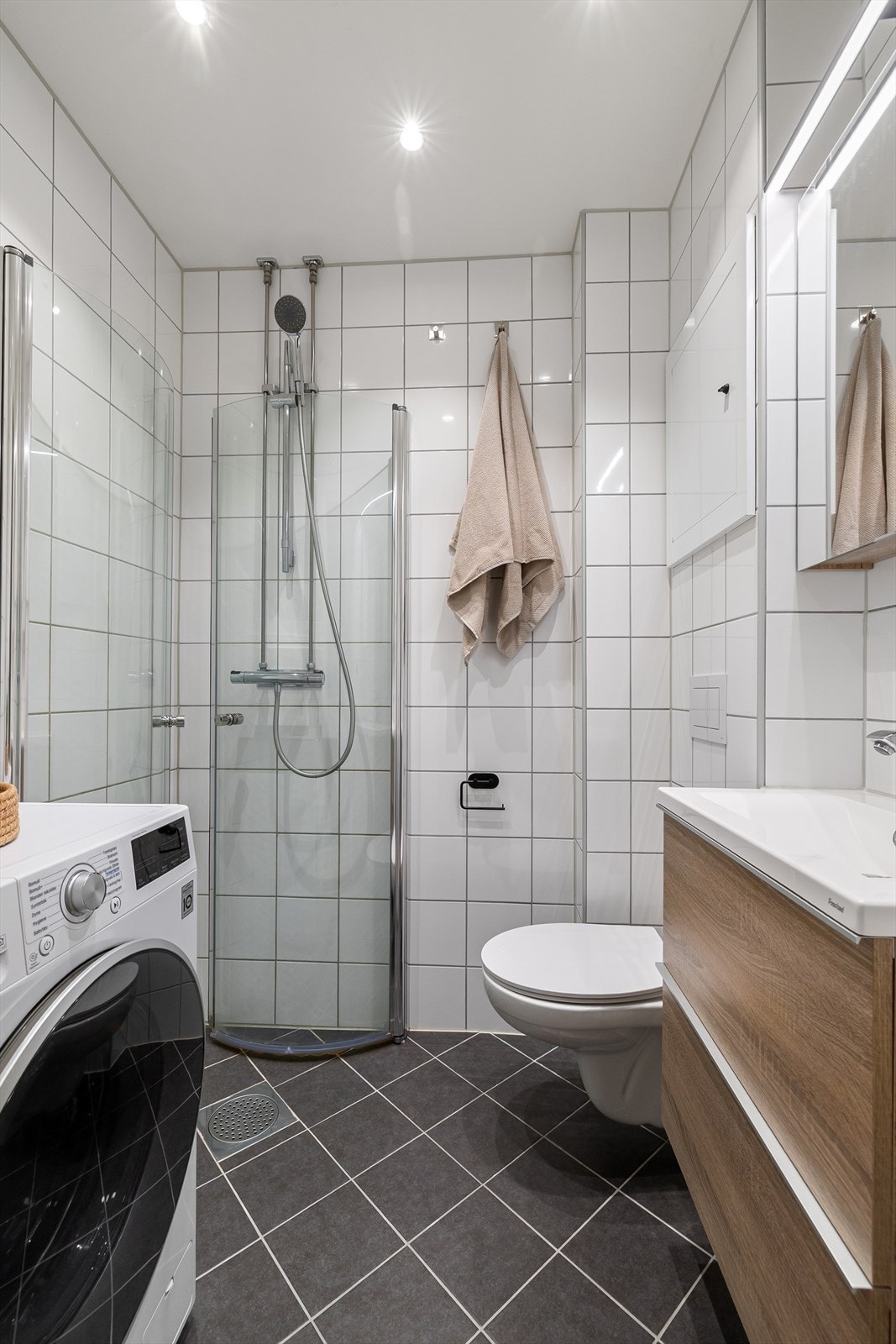 Helfliset bad fra 2019 med varmekabler i gulv, downlights i himling og opplegg for vaskemaskin Galleribilde